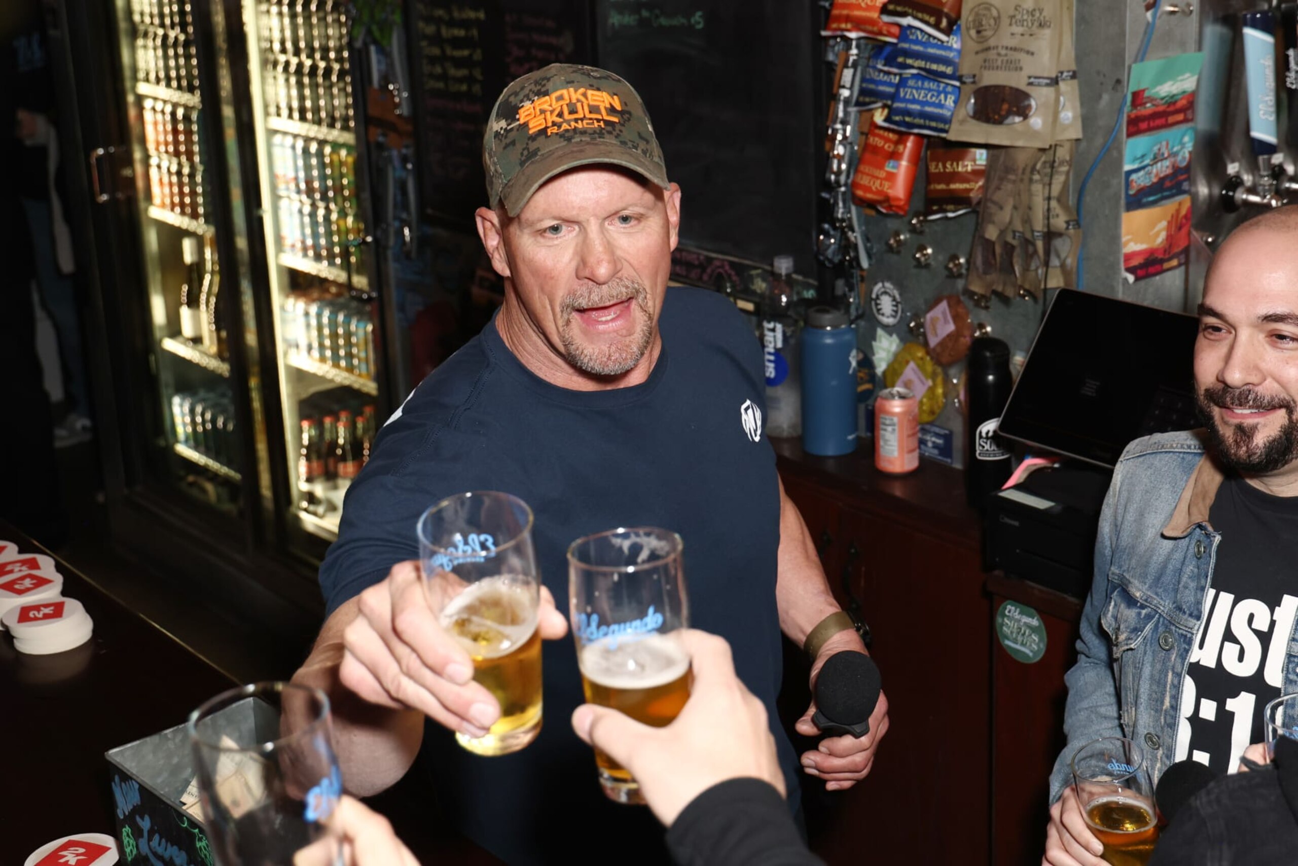 EL SEGUNDO, CALIFORNIA - MARCH 16: "Stone Cold" Steve Austin (C) speaks during WWE 2K23 Launch Event at El Segundo Brewing Company on March 16, 2023 in El Segundo, California. (Photo by Joe Scarnici/Getty Images for 2K )