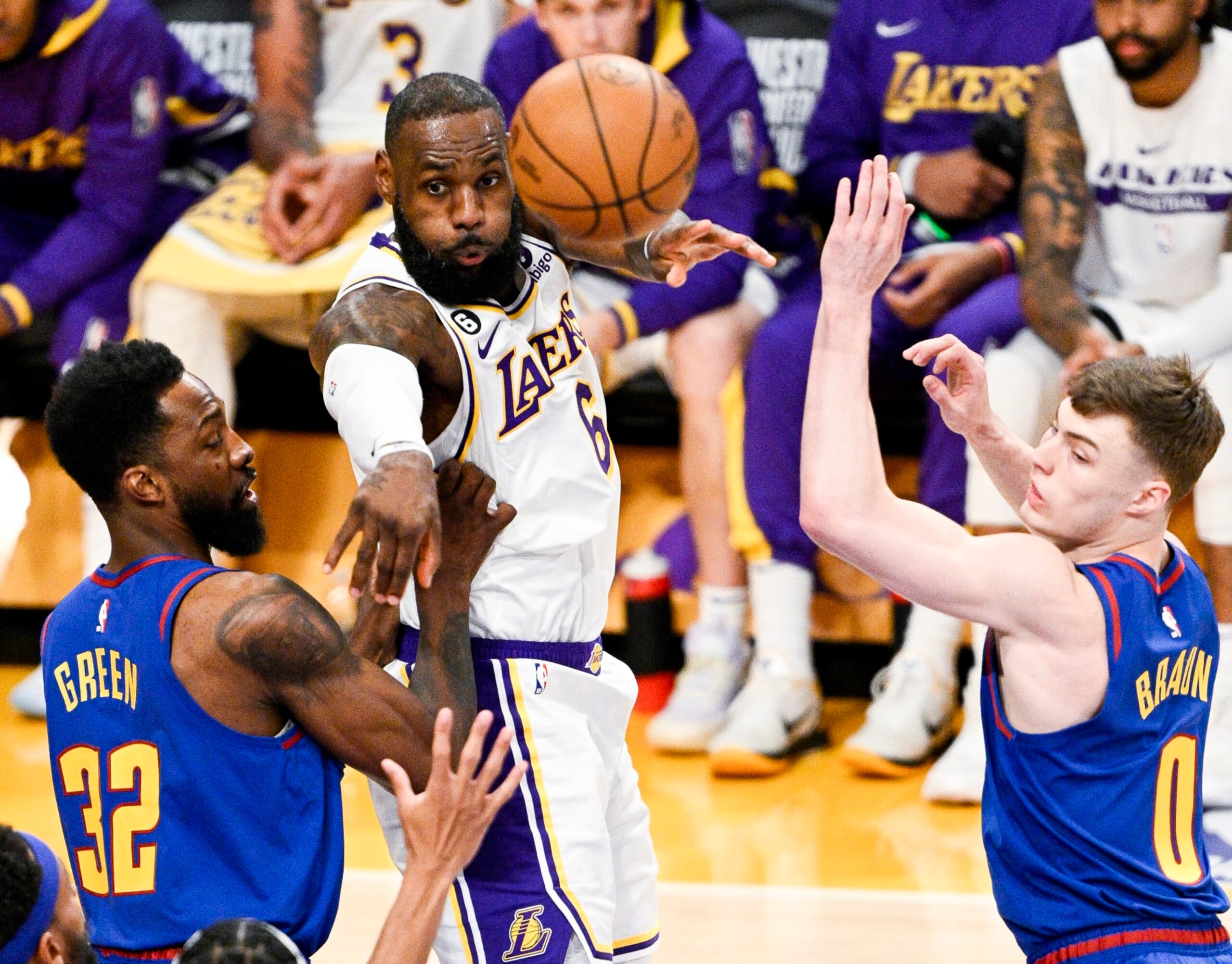 LOS ANGELES, CA - MAY 20: Los Angeles Lakers forward LeBron James, center, passes the ball while defended by ]Denver Nuggets forward Jeff Green, left, and guard Christian Braun during the first quarter of game three in the NBA Playoffs Western Conference Finals at Crypto.com Arena on Saturday, May 20, 2023 in Los Angeles, CA. (Gina Ferazzi / Los Angeles Times via Getty Images)