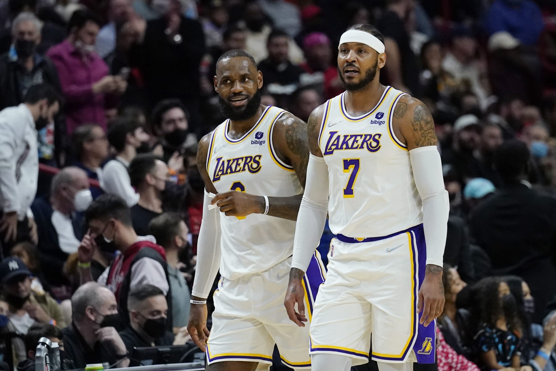 Los Angeles Lakers forward LeBron James, left talks with forward Carmelo Anthony (7) during the first half of an NBA basketball game against the Miami Heat, Sunday, Jan. 23, 2022, in Miami. (AP Photo/Lynne Sladky)