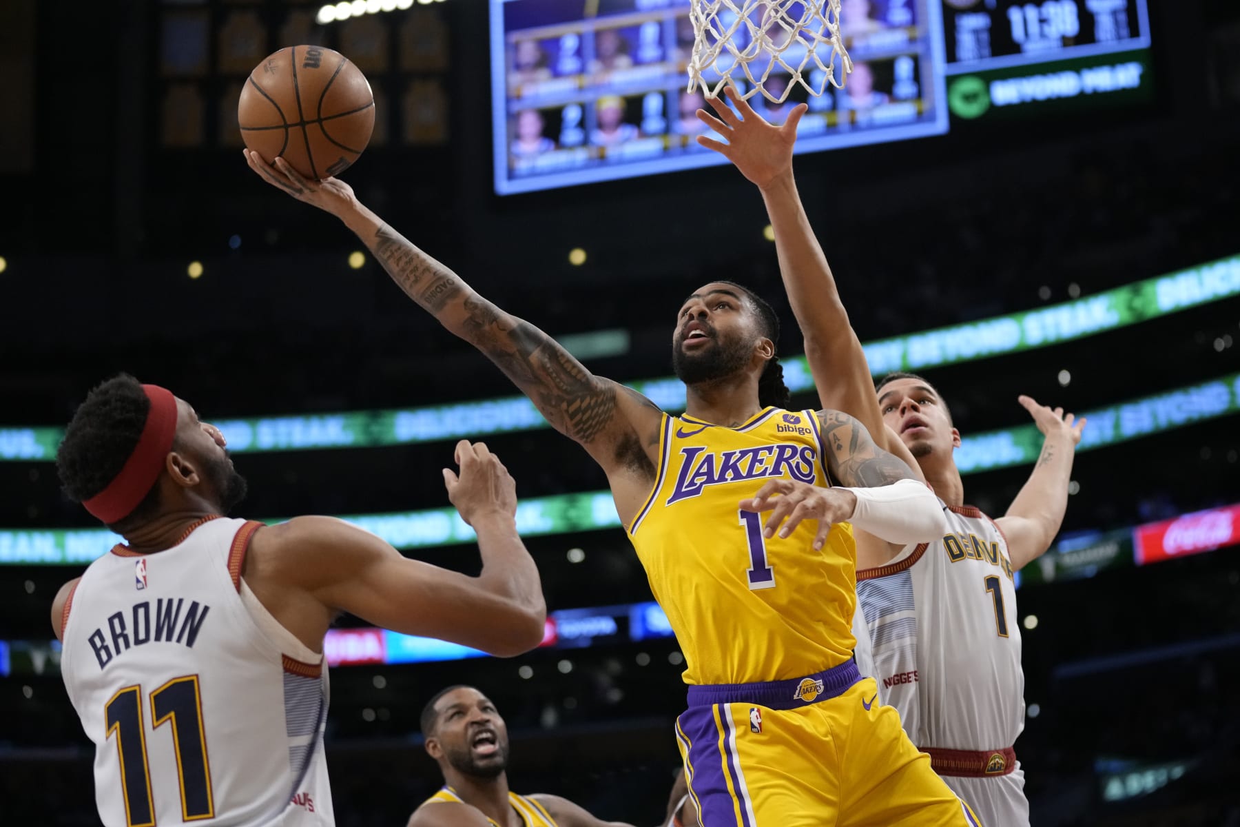 Los Angeles Lakers guard D'Angelo Russell (1) shoots between Denver Nuggets forward Michael Porter Jr. (1) and forward Bruce Brown (11) in the first half of Game 4 of the NBA basketball Western Conference Final series Monday, May 22, 2023, in Los Angeles. (AP Photo/Ashley Landis) Los Angeles Lakers guard D'Angelo Russell (1) shoots between Denver Nuggets forward Michael Porter Jr. (1) and forward Bruce Brown (11) in the first half of Game 4 of the NBA basketball Western Conference Final series Monday, May 22, 2023, in Los Angeles. (AP Photo/Ashley Landis)