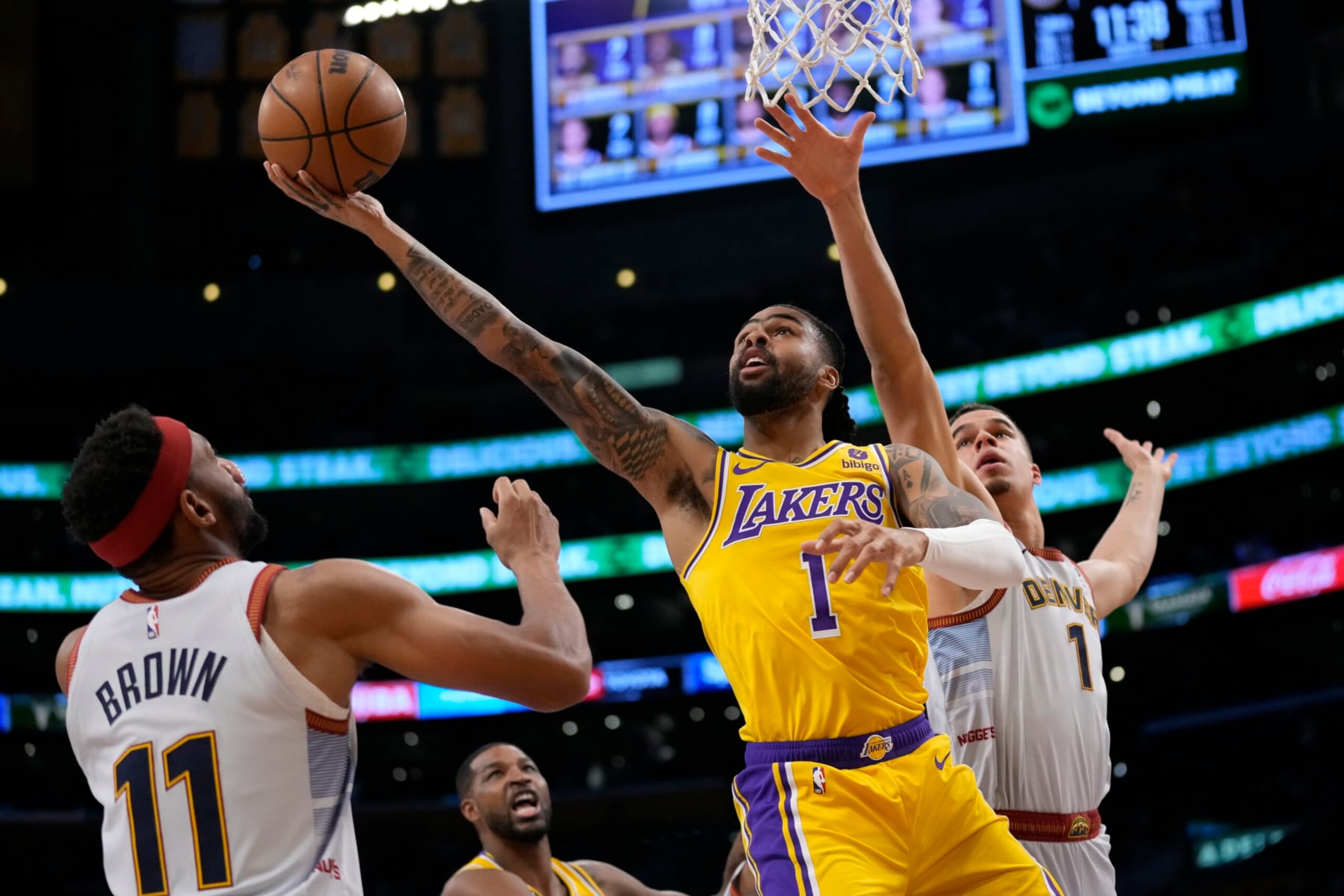 Los Angeles Lakers guard D'Angelo Russell (1) shoots between Denver Nuggets forward Michael Porter Jr. (1) and forward Bruce Brown (11) in the first half of Game 4 of the NBA basketball Western Conference Final series Monday, May 22, 2023, in Los Angeles. (AP Photo/Ashley Landis) Los Angeles Lakers guard D'Angelo Russell (1) shoots between Denver Nuggets forward Michael Porter Jr. (1) and forward Bruce Brown (11) in the first half of Game 4 of the NBA basketball Western Conference Final series Monday, May 22, 2023, in Los Angeles. (AP Photo/Ashley Landis)