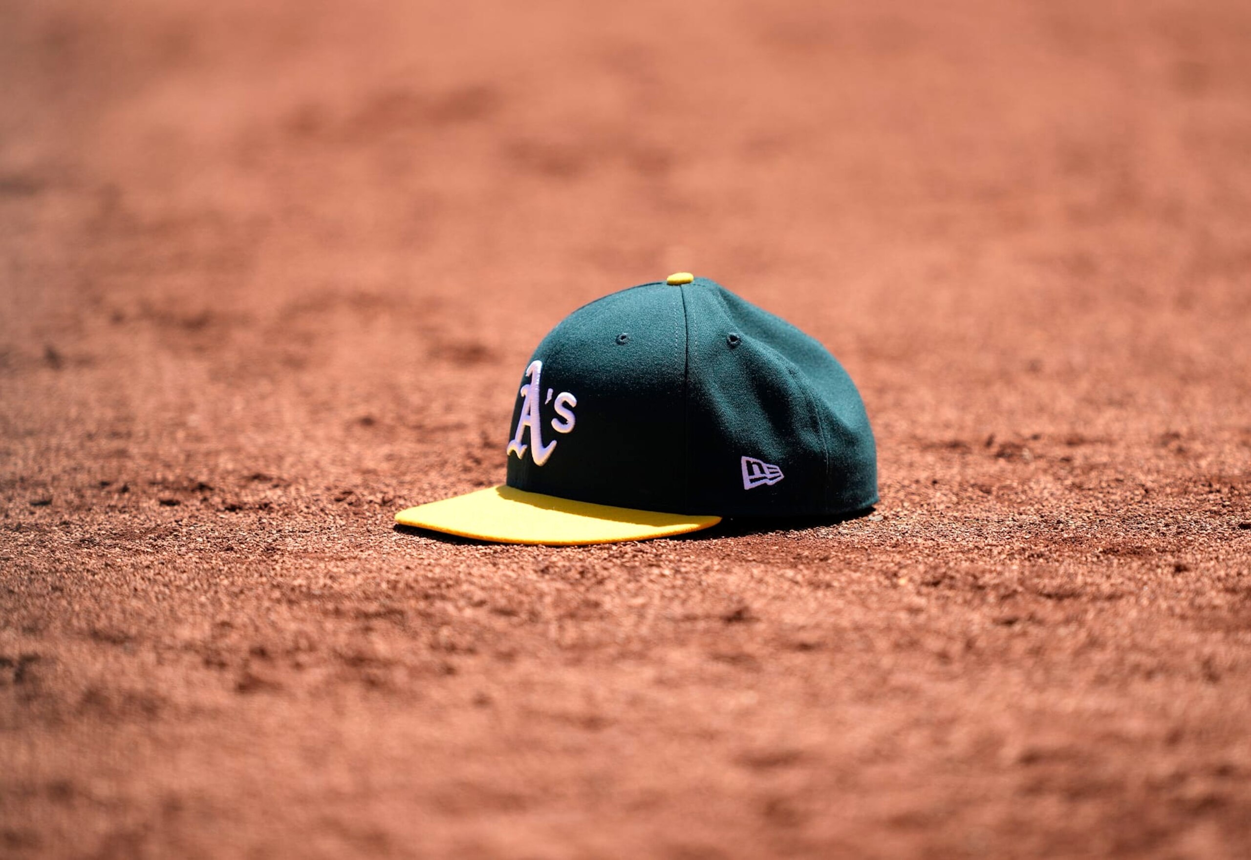 OAKLAND, CALIFORNIA - MAY 17: A detailed view of a cap belonging to a Oakland Athletics player is seen sitting in the dirt of the warning track during a game against the Arizona Diamondbacks at RingCentral Coliseum on May 17, 2023 in Oakland, California. (Photo by Thearon W. Henderson/Getty Images)
