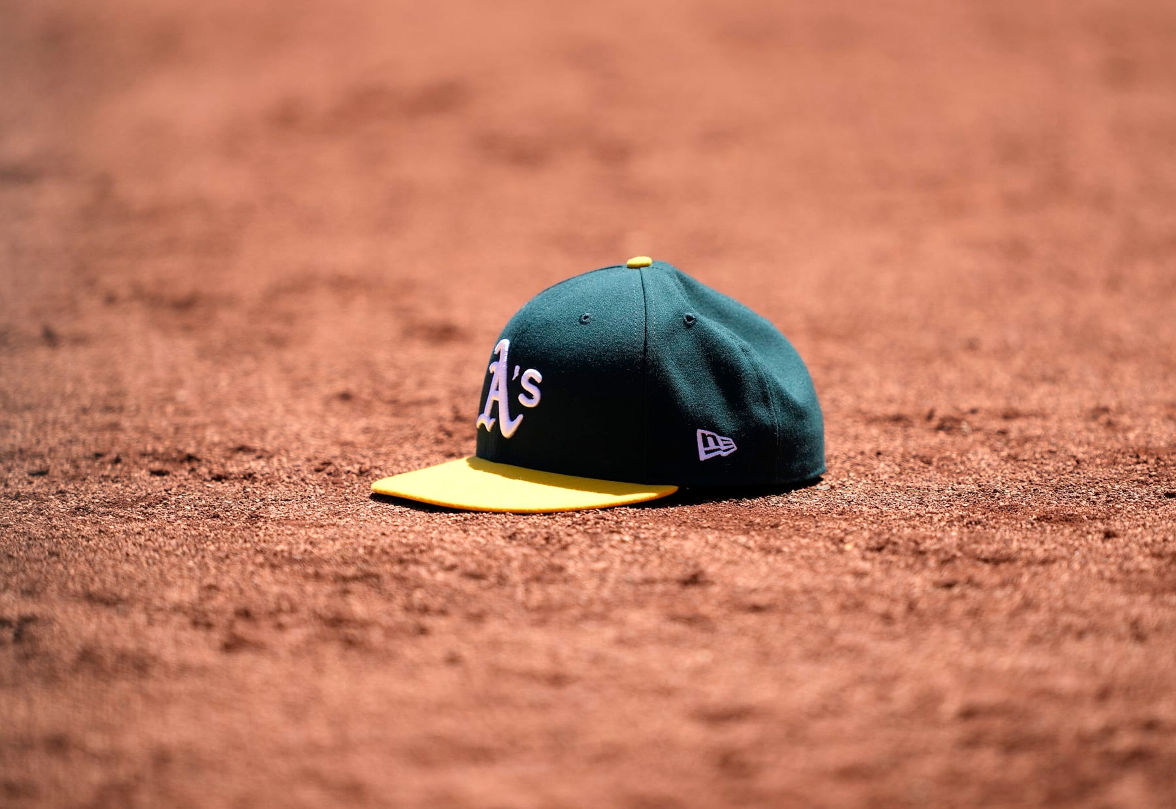 OAKLAND, CALIFORNIA - MAY 17: A detailed view of a cap belonging to a Oakland Athletics player is seen sitting in the dirt of the warning track during a game against the Arizona Diamondbacks at RingCentral Coliseum on May 17, 2023 in Oakland, California. (Photo by Thearon W. Henderson/Getty Images)