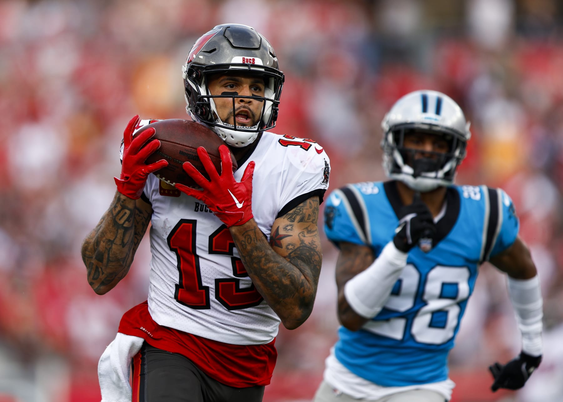 TAMPA, FL - JANUARY 1: Mike Evans #13 of the Tampa Bay Buccaneers catches a pass past Keith Taylor Jr. #28 of the Carolina Panthers to score a touchdown during the second quarter of an NFL football game at Raymond James Stadium on January 1, 2023 in Tampa, Florida. (Photo by Kevin Sabitus/Getty Images)