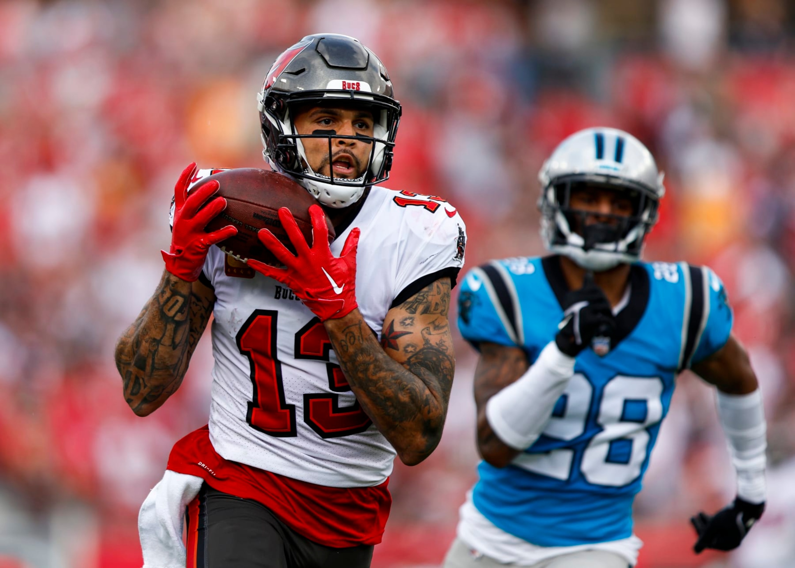 TAMPA, FL - JANUARY 1: Mike Evans #13 of the Tampa Bay Buccaneers catches a pass past Keith Taylor Jr. #28 of the Carolina Panthers to score a touchdown during the second quarter of an NFL football game at Raymond James Stadium on January 1, 2023 in Tampa, Florida. (Photo by Kevin Sabitus/Getty Images)