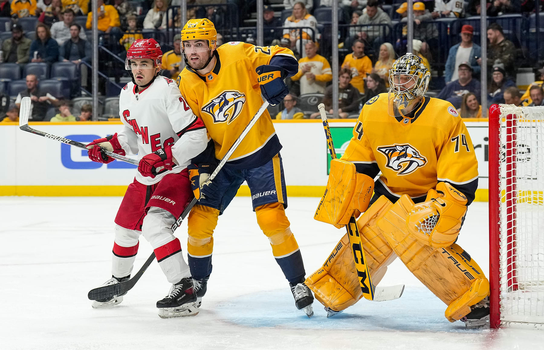 NASHVILLE, TENNESSEE - APRIL 6: Seth Jarvis #24 of the Carolina Hurricanes battles in front of the net against Jake Livingstone #23 and Juuse Saros #74 of the Nashville Predators during an NHL game at Bridgestone Arena on April 6, 2023 in Nashville, Tennessee. (Photo by John Russell/NHLI via Getty Images)