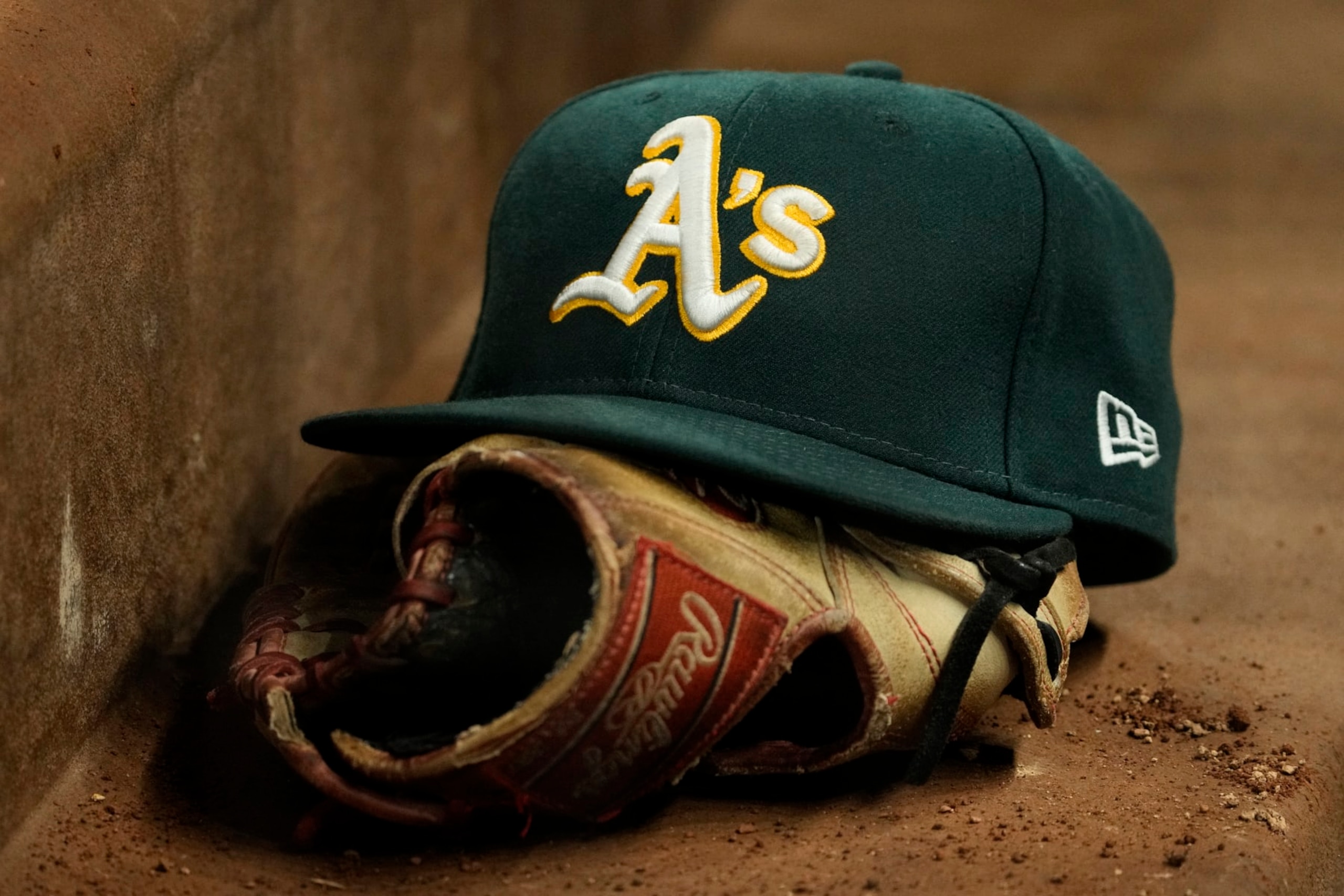 ARLINGTON, TEXAS - APRIL 21: A close up view of an Oakland Athletics hat and Rawlings glove during the game against the Texas Rangers at Globe Life Field on April 21, 2023 in Arlington, Texas. (Photo by Sam Hodde/Getty Images)