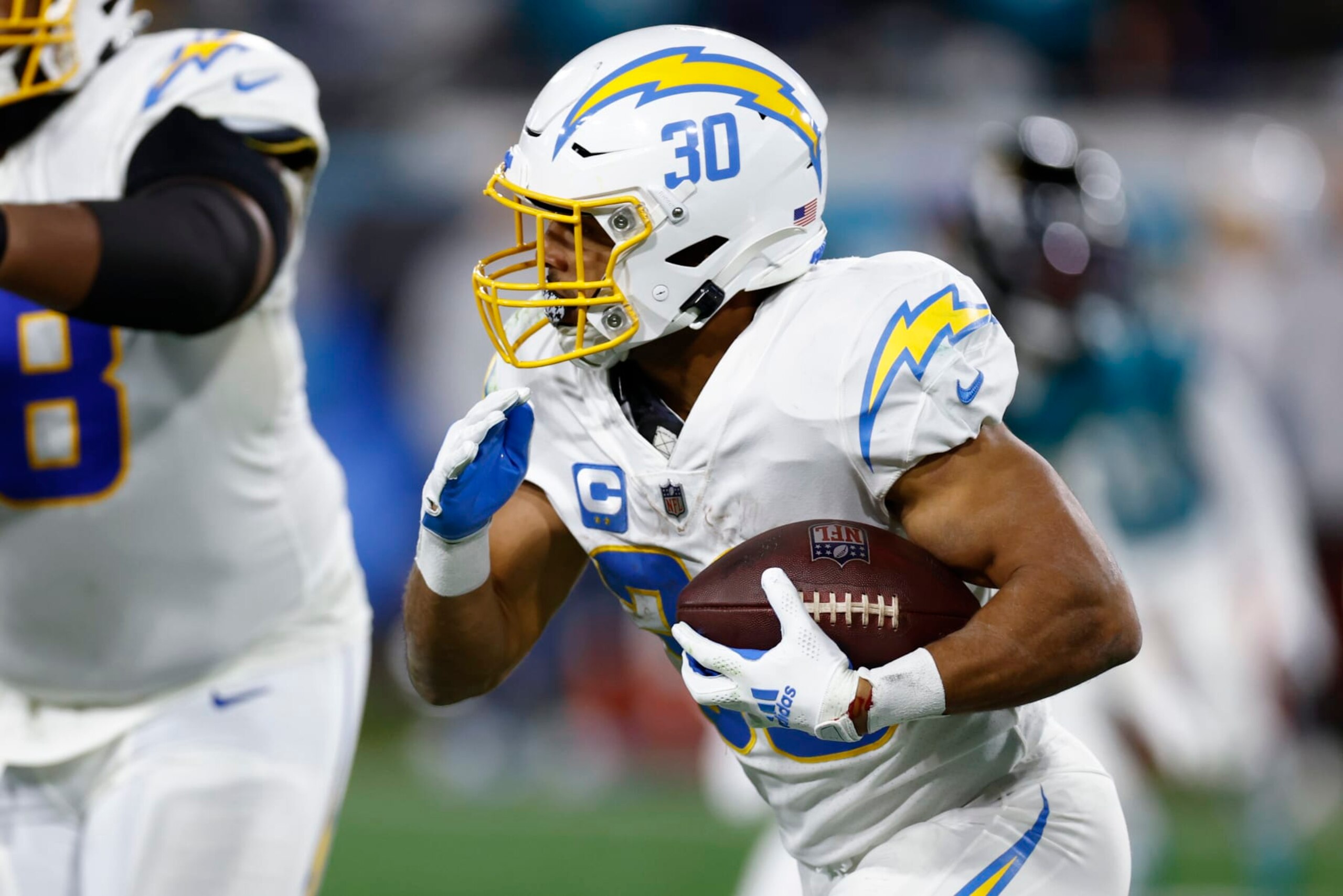 JACKSONVILLE, FLORIDA - JANUARY 14: Austin Ekeler #30 of the Los Angeles Chargers carries the ball against the Jacksonville Jaguars during the first half of the game in the AFC Wild Card playoff game at TIAA Bank Field on January 14, 2023 in Jacksonville, Florida. (Photo by Douglas P. DeFelice/Getty Images)