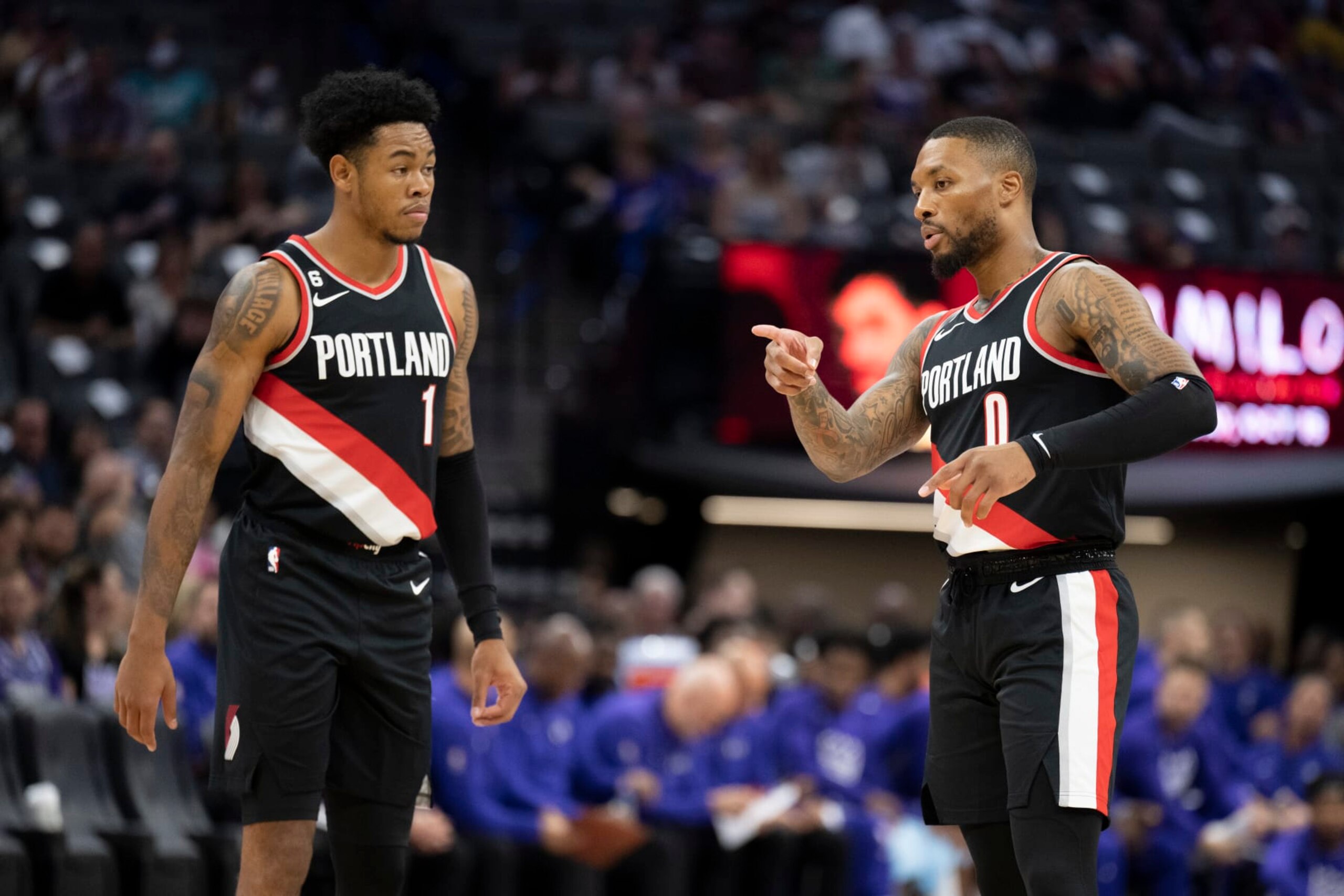 Portland Trail Blazer Damian Lillard (0) explains defensive coverage with teammate Anfernee Simons (1) in the first quarter of an NBA preseason basketball game in Sacramento, Calif., Sunday, Oct. 9, 2022. (AP Photo/José Luis Villegas)