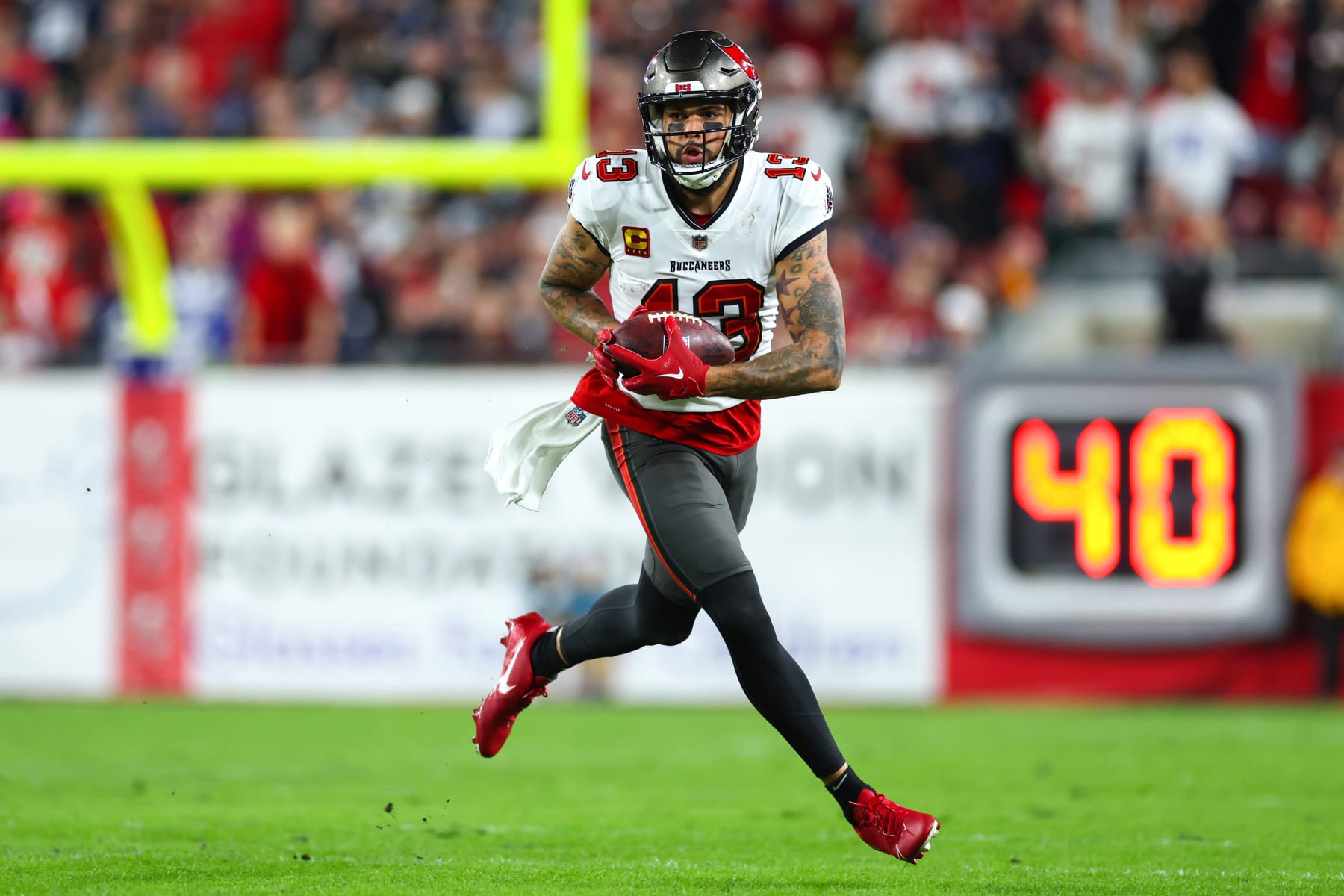 TAMPA, FLORIDA - JANUARY 16: Mike Evans #13 of the Tampa Bay Buccaneers carries the ball against the Dallas Cowboys during the third quarter in the NFC Wild Card playoff game at Raymond James Stadium on January 16, 2023 in Tampa, Florida. (Photo by Mike Ehrmann/Getty Images)