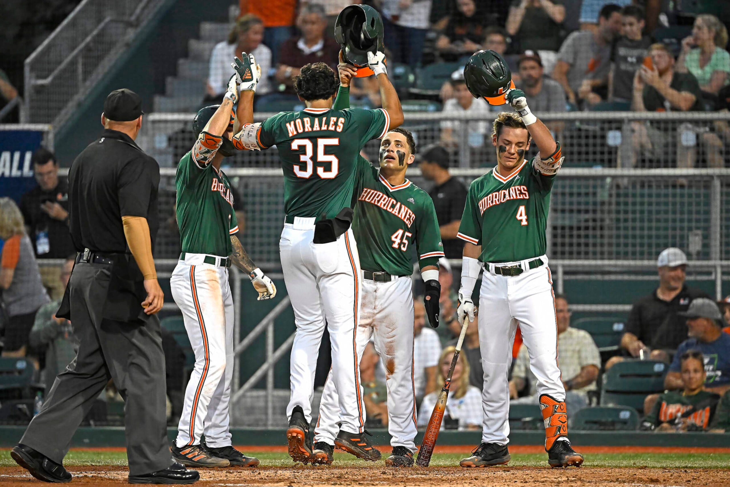 CORAL GABLES, FL - JUNE 02: Miami infielder Yohandy Morales (35) celebrates his three-run home run in the second inning with infielder CJ Kayfus (2), Edgardo Villegas (45) and infielder Blake Cyr (4) as the Miami Hurricanes faced the Maine Black Bears in the Coral Gables Regional on June 2, 2023, at Mark Light Field at Alex Rodriguez Park in Coral Gables, Florida. (Photo by Samuel Lewis/Icon Sportswire via Getty Images)