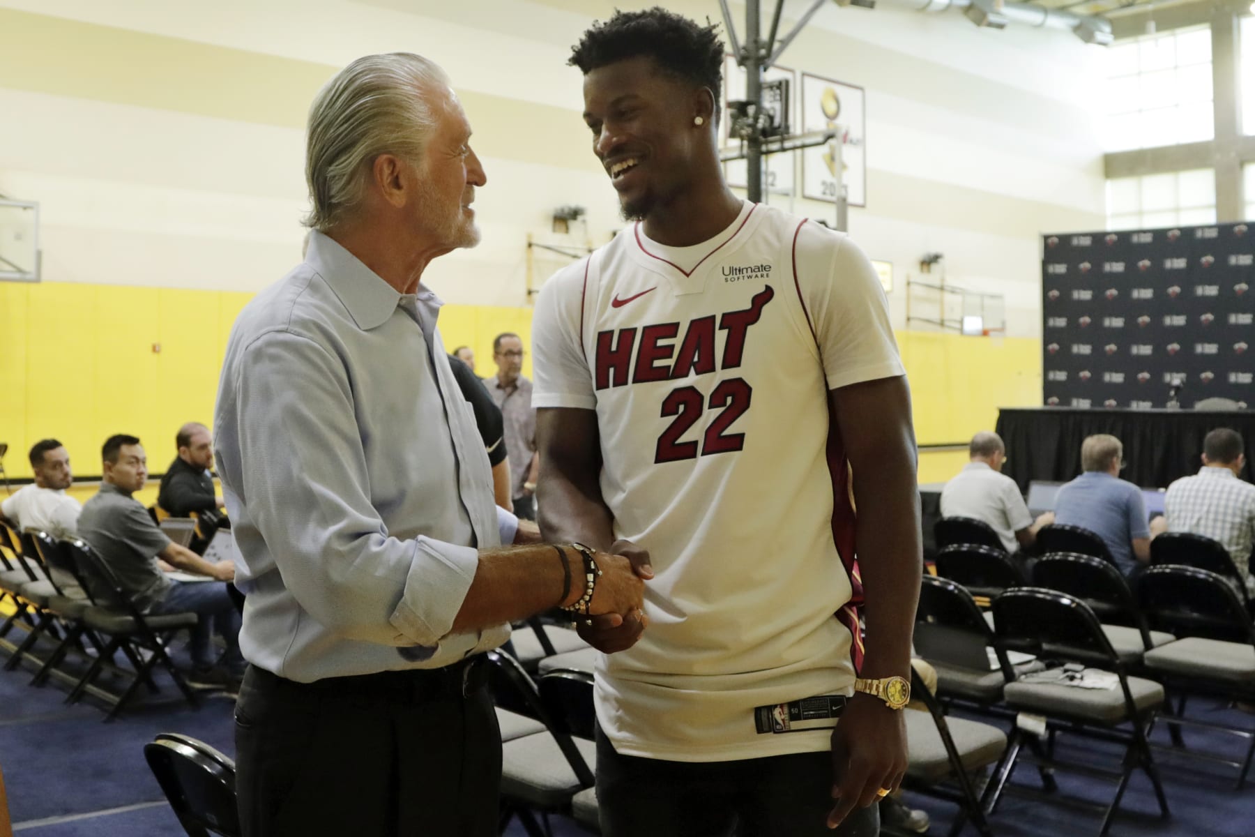 Miami Heat guard Jimmy Butler (22) shakes hands with Miami Heat President Pat Riley, left, following an NBA basketball news conference, Friday, Sept. 27, 2019, in Miami. Butler spoke publicly for the first time since the July trade that brought him to South Florida as the new face of the franchise. (AP Photo/Lynne Sladky)
