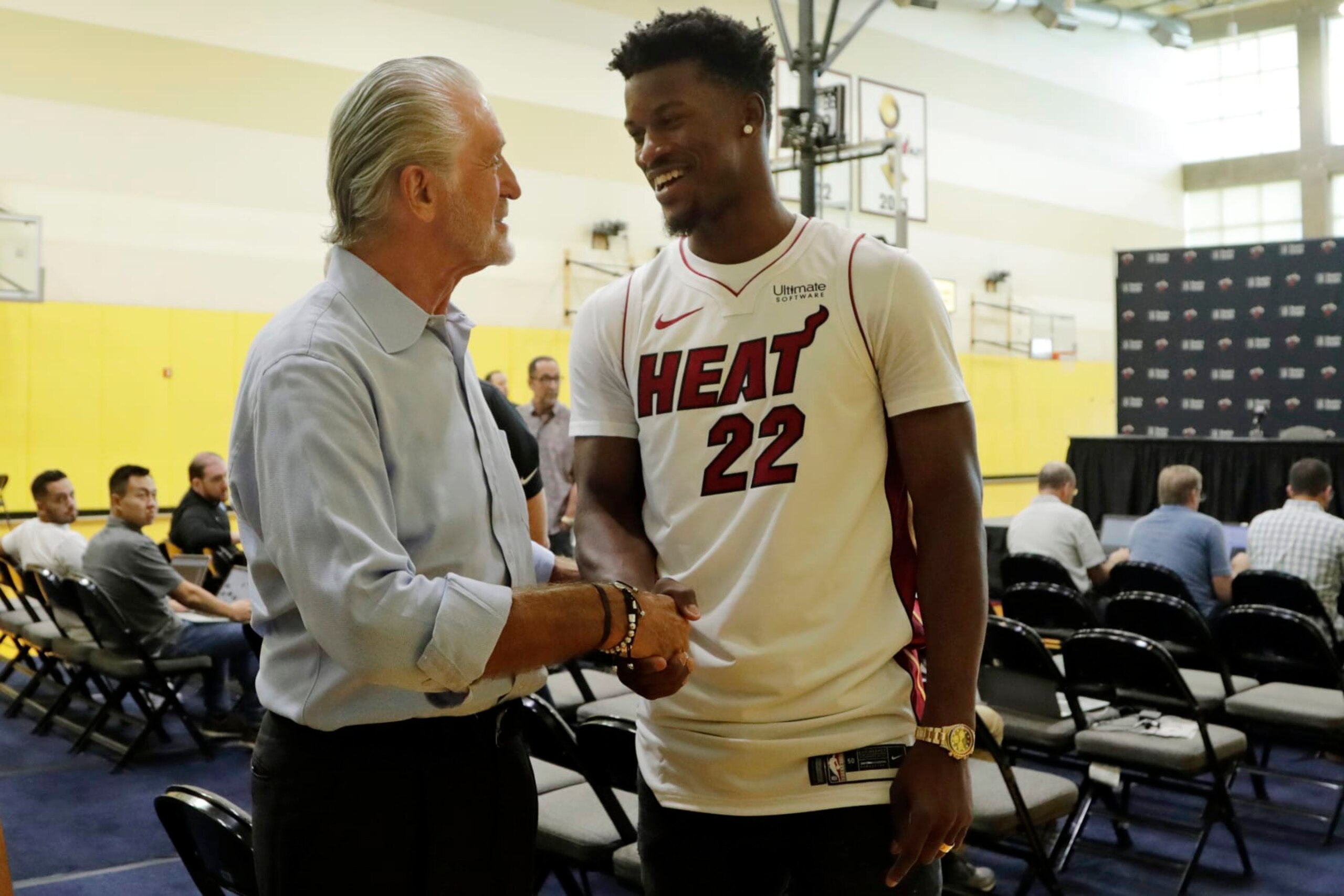 Miami Heat guard Jimmy Butler (22) shakes hands with Miami Heat President Pat Riley, left, following an NBA basketball news conference, Friday, Sept. 27, 2019, in Miami. Butler spoke publicly for the first time since the July trade that brought him to South Florida as the new face of the franchise. (AP Photo/Lynne Sladky)