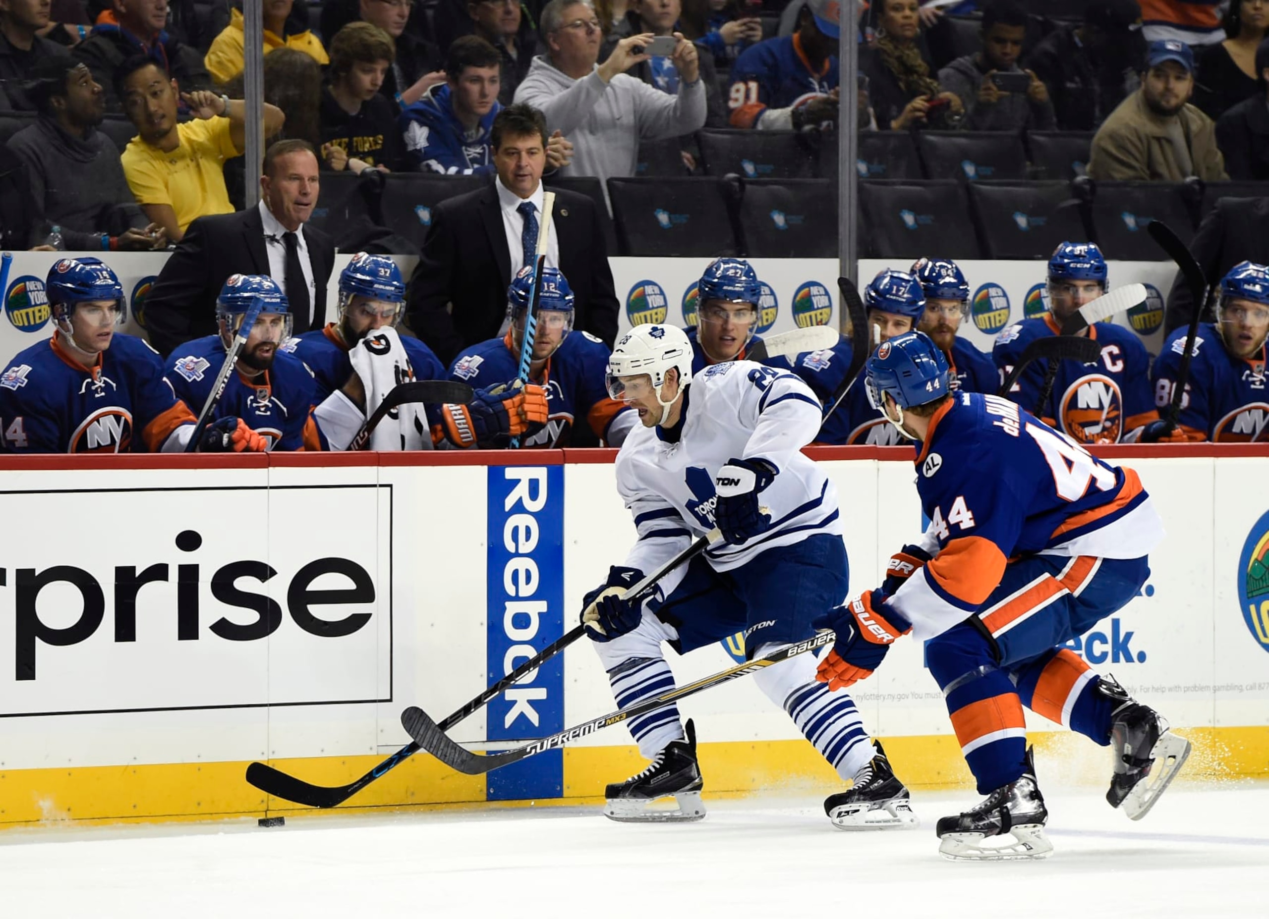 New York Islanders assistant coach Greg Cronin, left and head coach Jack Capuano watch Toronto Maple Leafs right wing Brad Boyes (28) control the puck against Islanders defenseman Calvin de Haan (44) during an NHL hockey game on Sunday, Dec. 27, 2015, in New York. (AP Photo/Kathy Kmonicek)