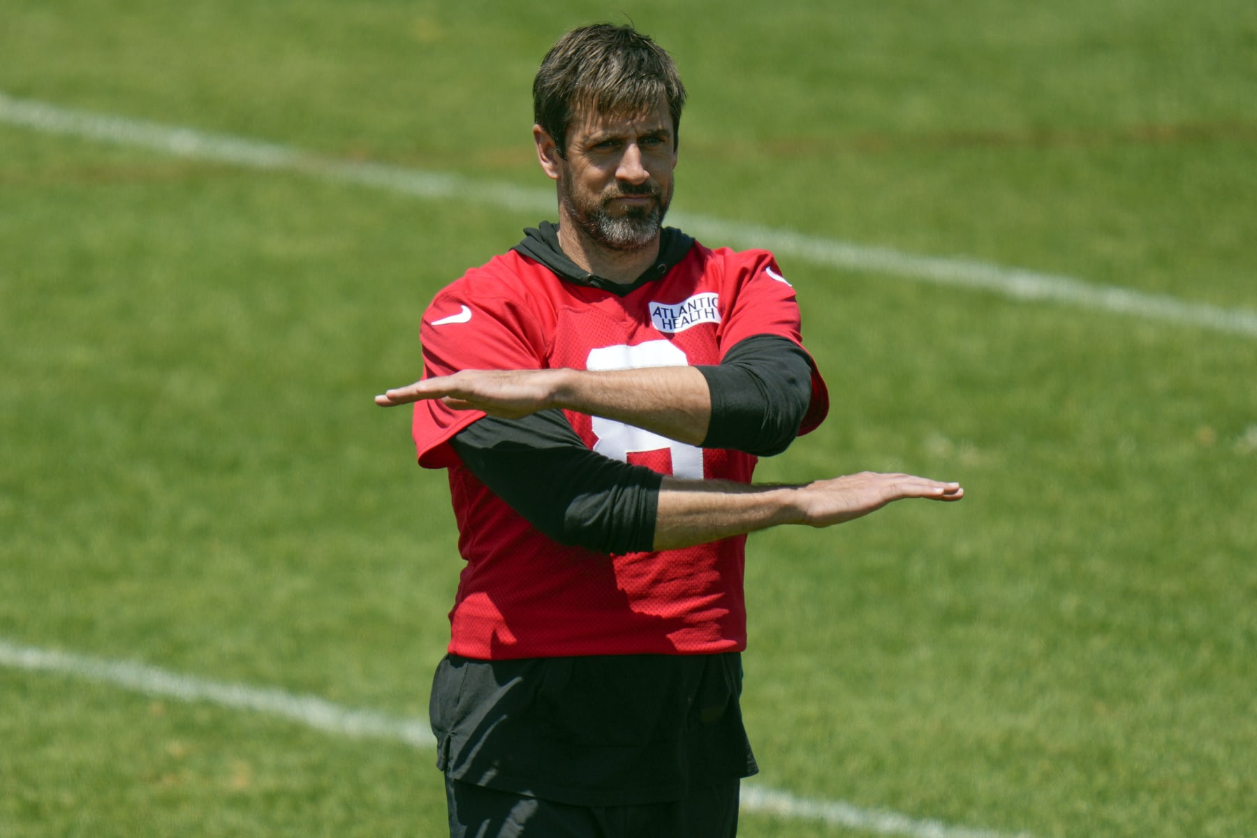 New York Jets quarterback Aaron Rodgers (8) gestures while watching teammates run drills during NFL football practice at the team's training facility in Florham Park, N.J., Wednesday, May 31, 2023. (AP Photo/Seth Wenig)