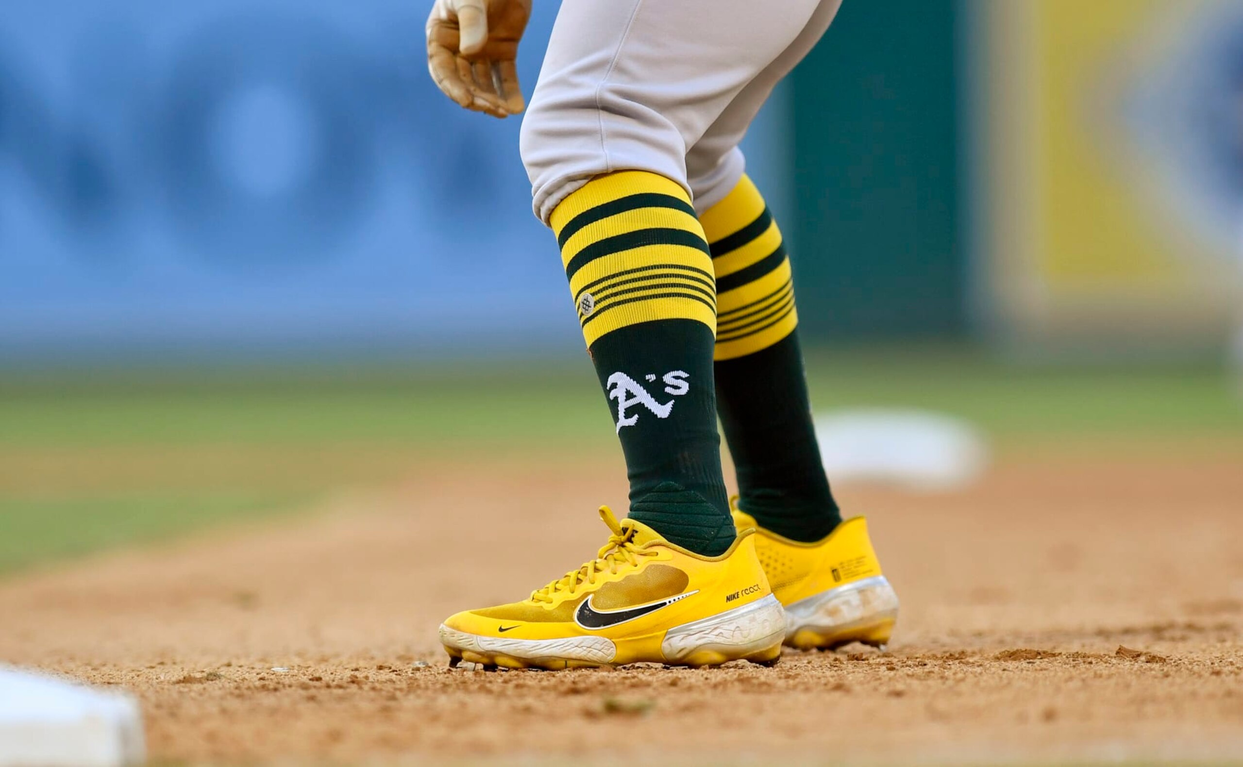 WASHINGTON, DC - SEPTEMBER 01: A close up view of Tony Kemps Oakland As logo baseball socks and yellow Nike React baseball cleats as he take a lead off from first base during the Oakland Athletics As versus Washington Nationals MLB game at Nationals Park on September 1, 2022 in Washington, D.C.. (Photo by Randy Litzinger/Icon Sportswire via Getty Images)