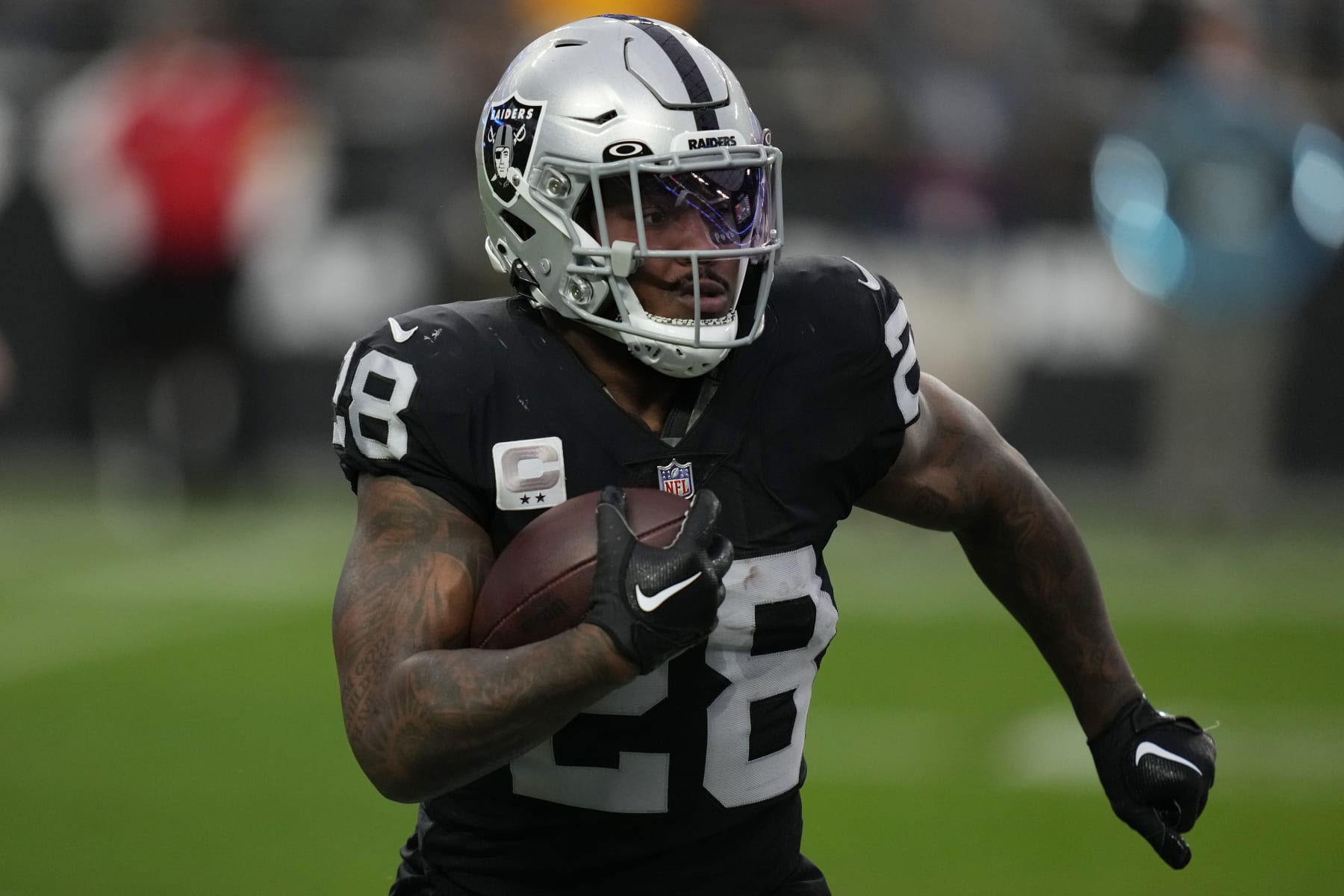 Las Vegas Raiders running back Josh Jacobs (28) runs against the Kansas City Chiefs during the first half of an NFL football game, Wednesday, Jan. 11, 2023, in Las Vegas. (AP Photo/John Locher)