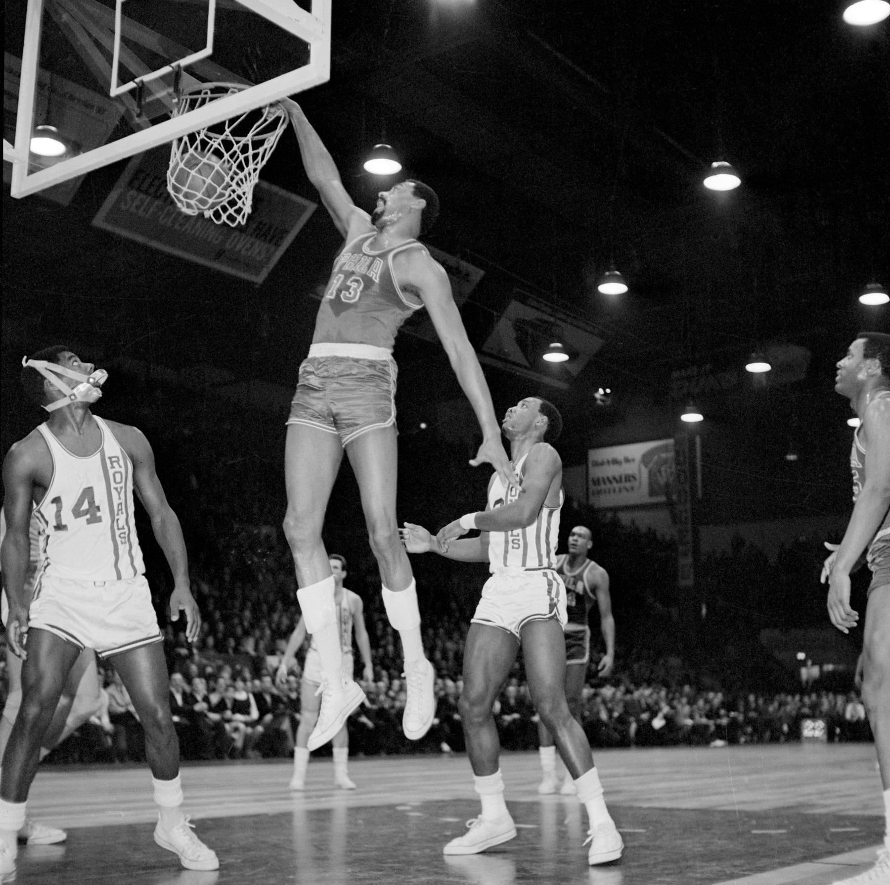 (Original Caption) Royals-76'ers. Cleveland, Ohio: Oscar Robertson (14) of Cincinnati watches Wilt Chamberlain of Philadelphia dunk one in 1st quarter action here February 17th.