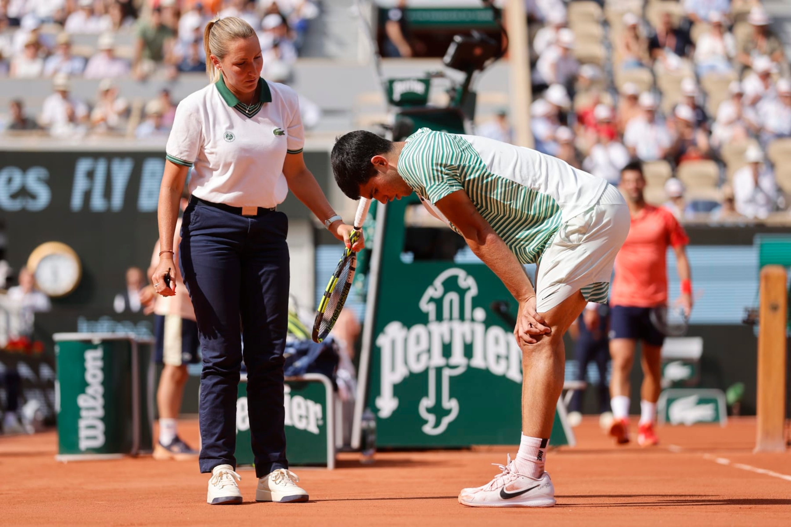 Spain's Carlos Alcaraz, right, speaks with chair umpire Aurelie Tourte of France as he reacts with pain at the end of the third game of the third set during his semifinal match of the French Open tennis tournament against Serbia's Novak Djokovic at the Roland Garros stadium in Paris, Friday, June 9, 2023. (AP Photo/Jean-Francois Badias) Spain's Carlos Alcaraz, right, speaks with chair umpire Aurelie Tourte of France as he reacts with pain at the end of the third game of the third set during his semifinal match of the French Open tennis tournament against Serbia's Novak Djokovic at the Roland Garros stadium in Paris, Friday, June 9, 2023. (AP Photo/Jean-Francois Badias)
