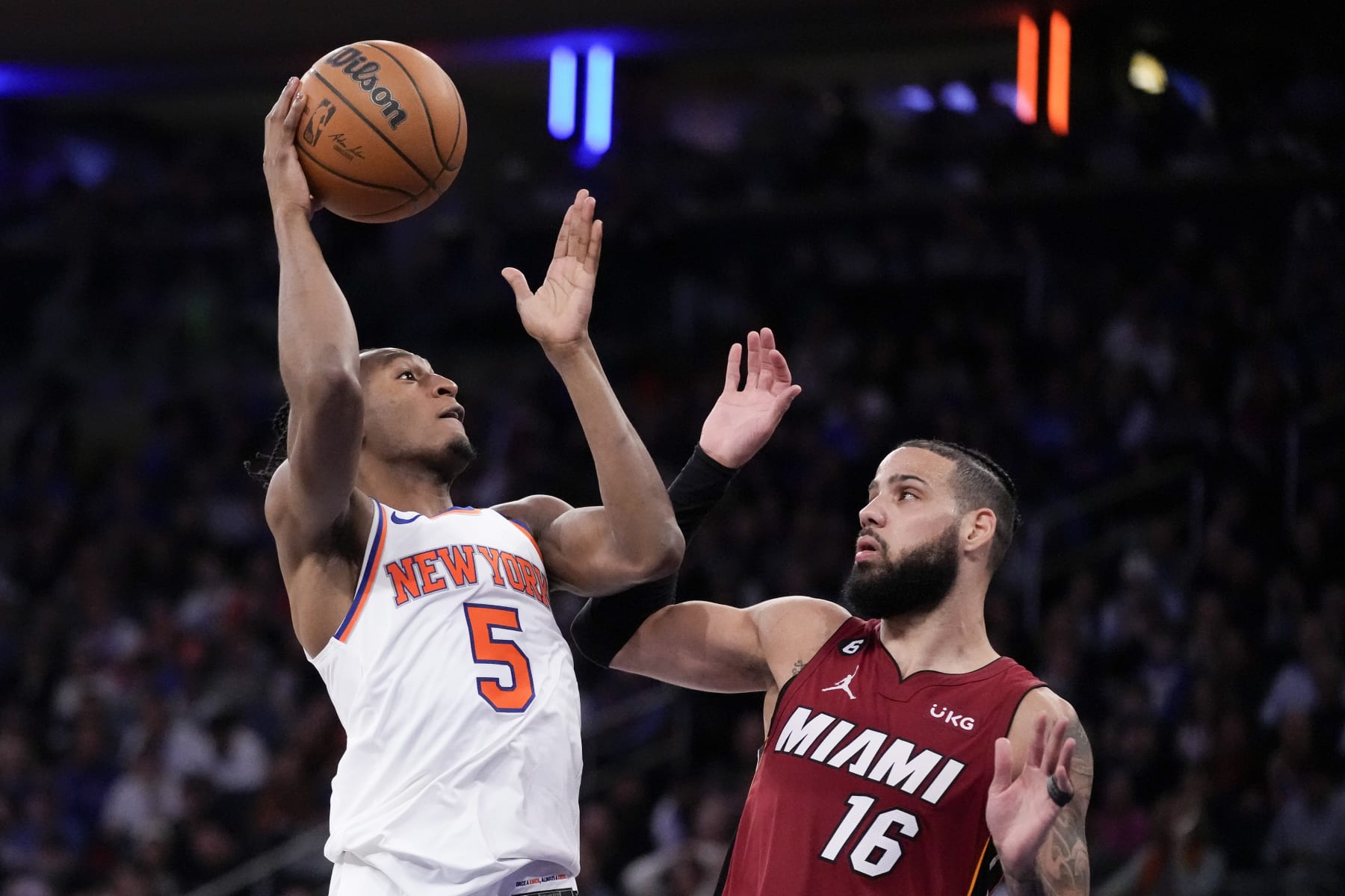 New York Knicks guard Immanuel Quickley (5) shoots against Miami Heat forward Caleb Martin (16) during the second half of Game 1 in the NBA basketball Eastern Conference semifinals playoff series, Sunday, April 30, 2023, in New York. (AP Photo/John Minchillo)