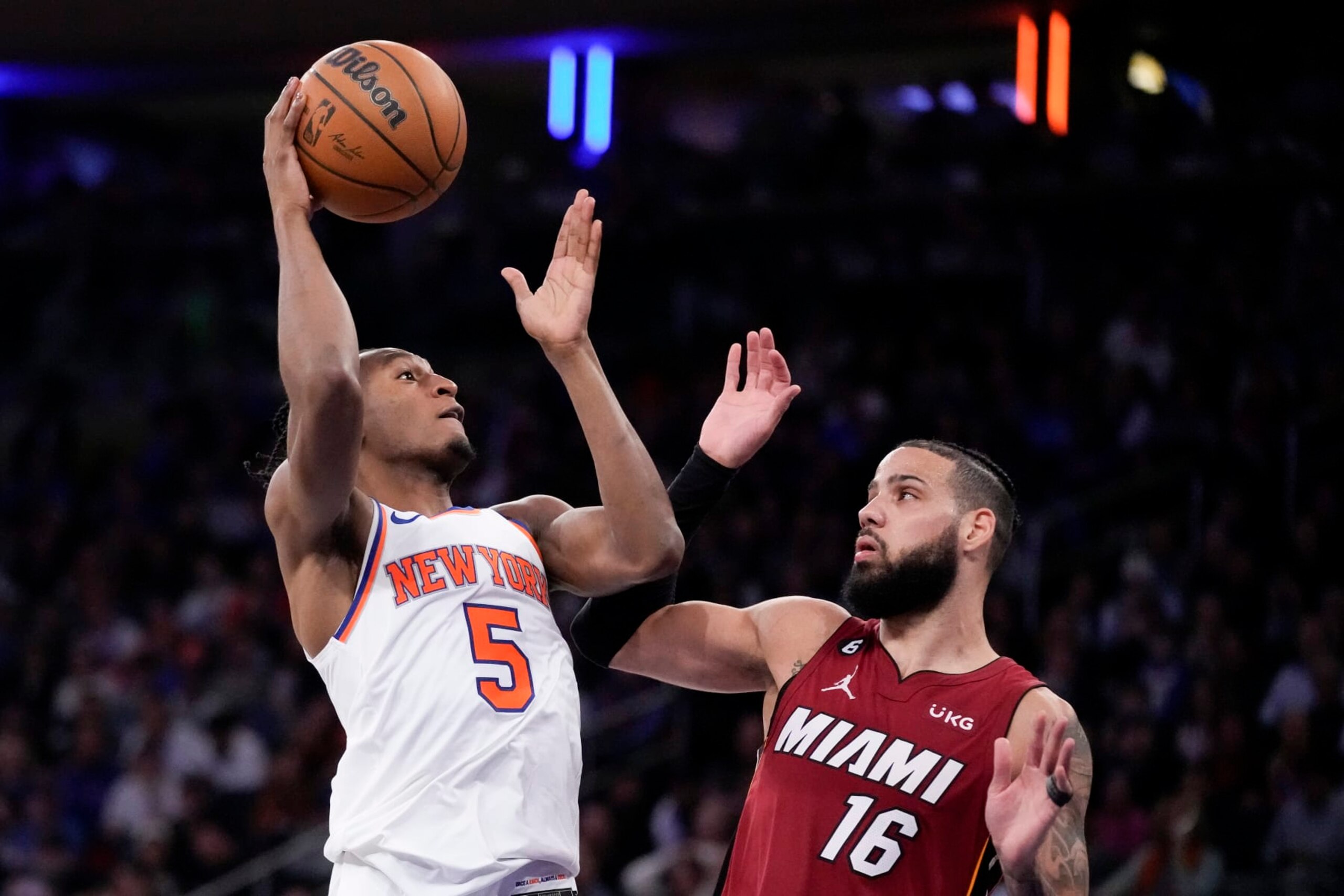New York Knicks guard Immanuel Quickley (5) shoots against Miami Heat forward Caleb Martin (16) during the second half of Game 1 in the NBA basketball Eastern Conference semifinals playoff series, Sunday, April 30, 2023, in New York. (AP Photo/John Minchillo)