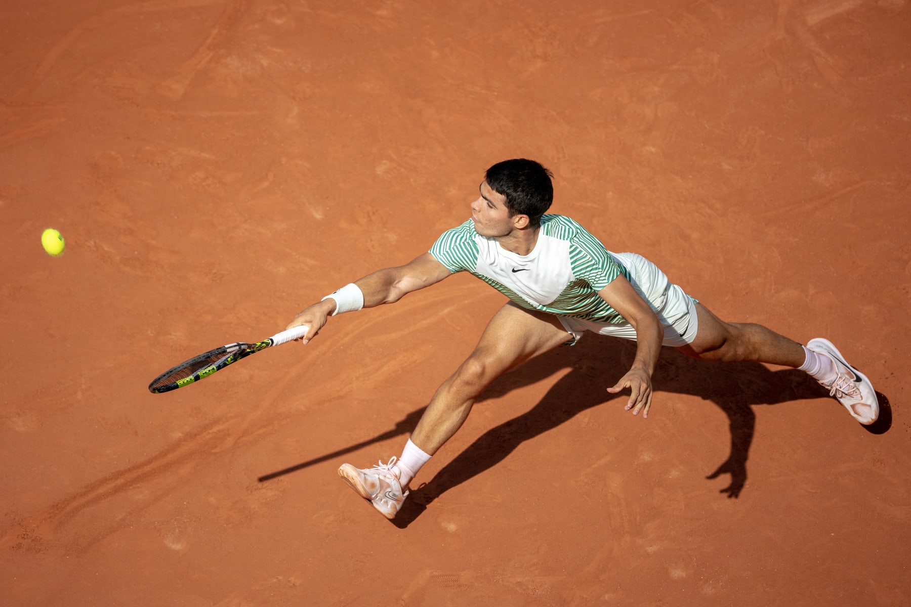PARIS, FRANCE - JUNE 9.  Carlos Alcaraz of Spain stretches for a shot behind the baseline during his match against Novak Djokovic of Serbia in the semi-final of the singles competition on Court Philippe Chatrier during the 2023 French Open Tennis Tournament at Roland Garros on June 9, 2023, in Paris, France. (Photo by Tim Clayton/Corbis via Getty Images)