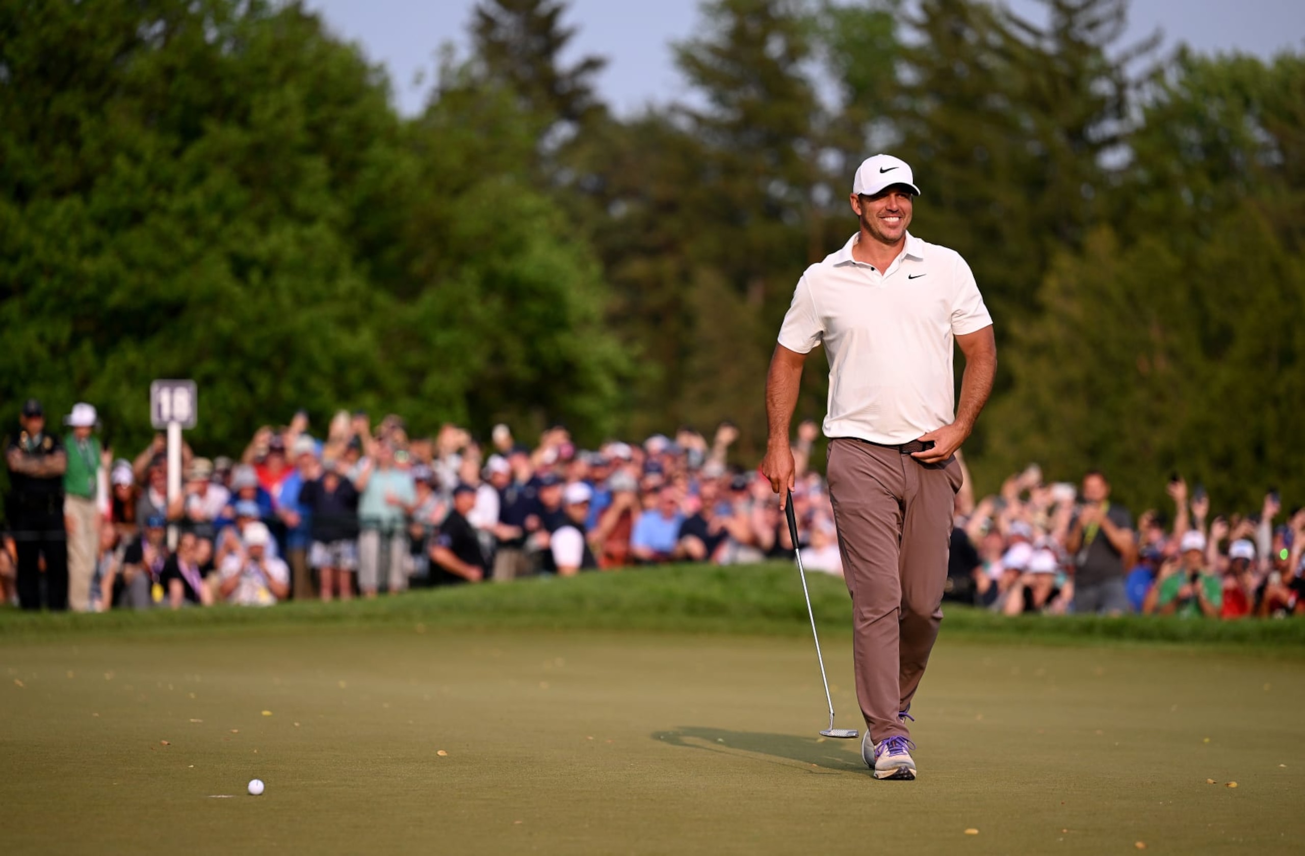 ROCHESTER, NEW YORK - MAY 21: Brooks Koepka of the United States smiles on the 18th green before his final putt to win during the final round of the 2023 PGA Championship at Oak Hill Country Club on May 21, 2023 in Rochester, New York. (Photo by Ross Kinnaird/Getty Images)