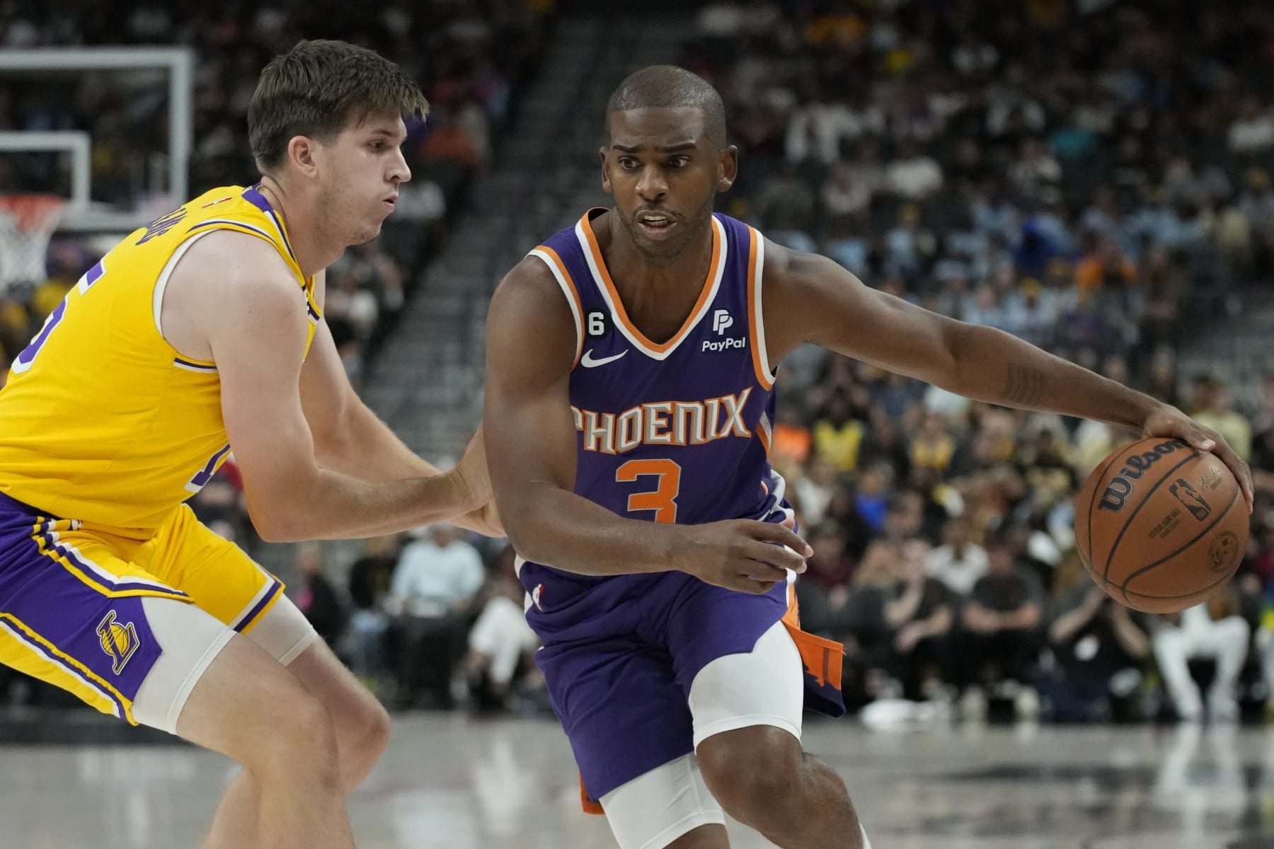 Phoenix Suns guard Chris Paul (3) drives around Los Angeles Lakers guard Austin Reaves (15) during the first half of a preseason NBA basketball game Wednesday, Oct. 5, 2022, in Las Vegas. (AP Photo/John Locher)