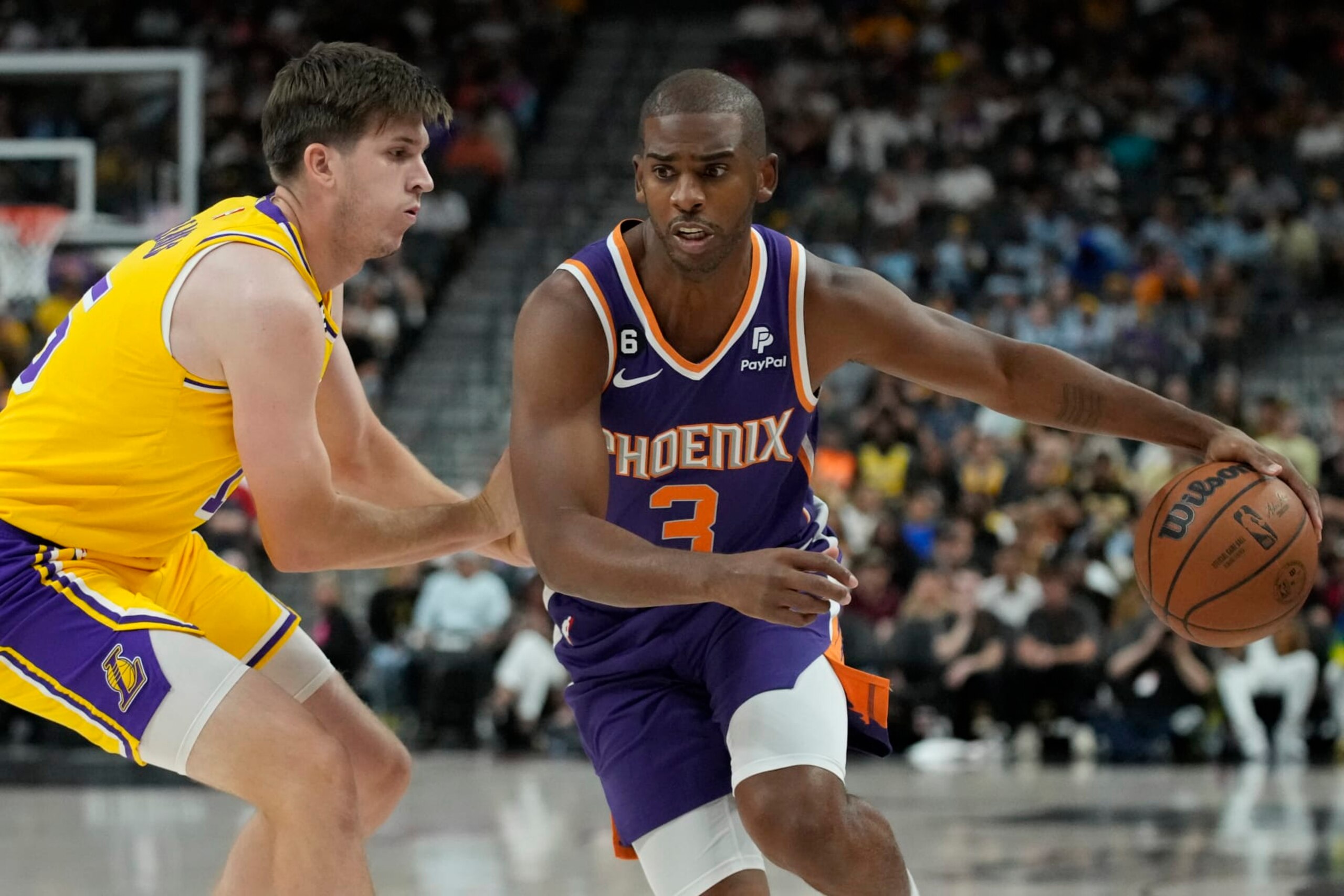 Phoenix Suns guard Chris Paul (3) drives around Los Angeles Lakers guard Austin Reaves (15) during the first half of a preseason NBA basketball game Wednesday, Oct. 5, 2022, in Las Vegas. (AP Photo/John Locher)
