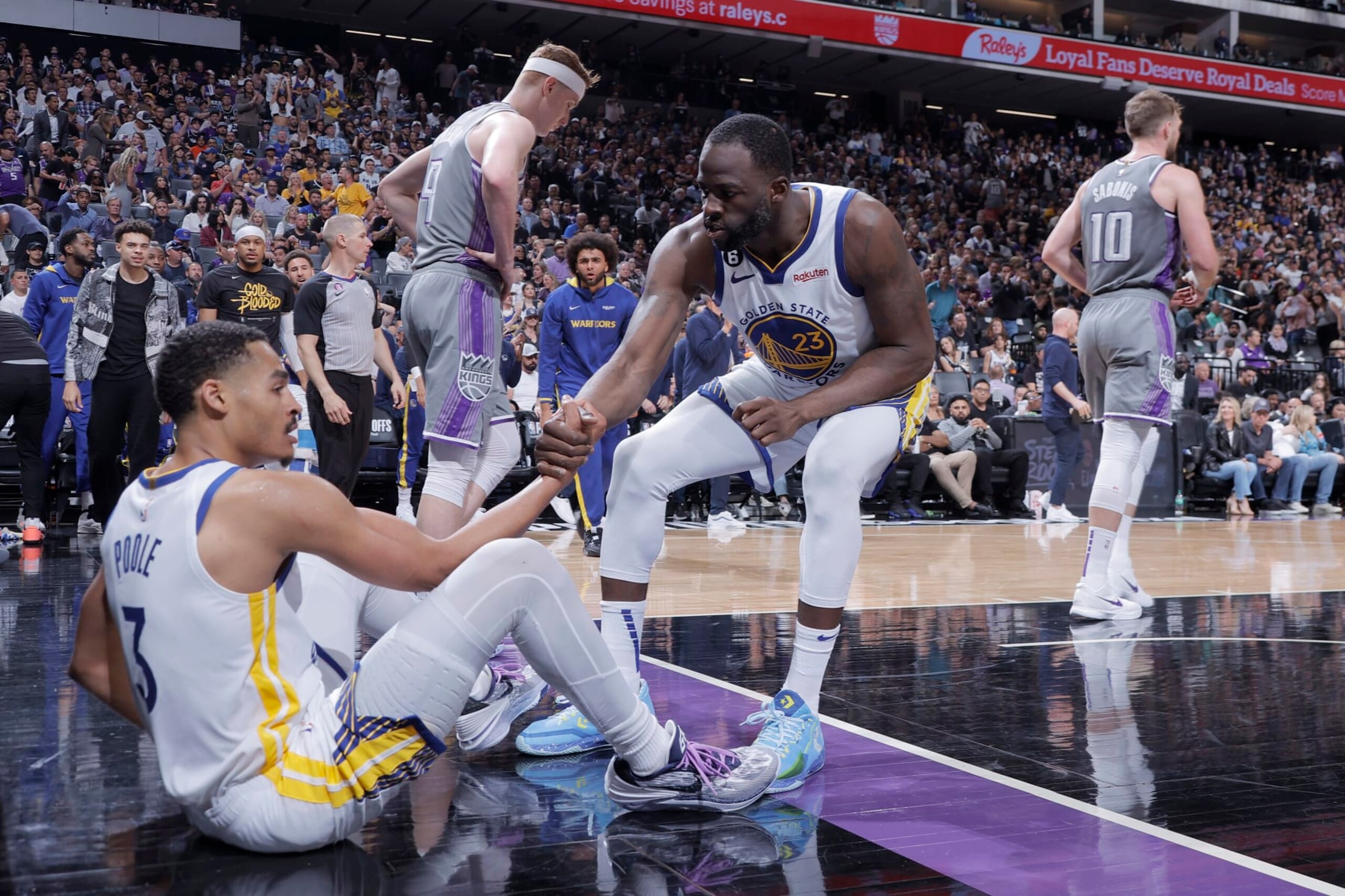 SACRAMENTO, CA - APRIL 26: Draymond Green #23 of the Golden State Warriors helps up Jordan Poole #3 during Round 1 Game 5 of the 2023 NBA Playoffs on April 26, 2023 at Golden 1 Center in SACRAMENTO, California. NOTE TO USER: User expressly acknowledges and agrees that, by downloading and or using this Photograph, user is consenting to the terms and conditions of the Getty Images License Agreement. Mandatory Copyright Notice: Copyright 2023 NBAE (Photo by Rocky Widner/NBAE via Getty Images)