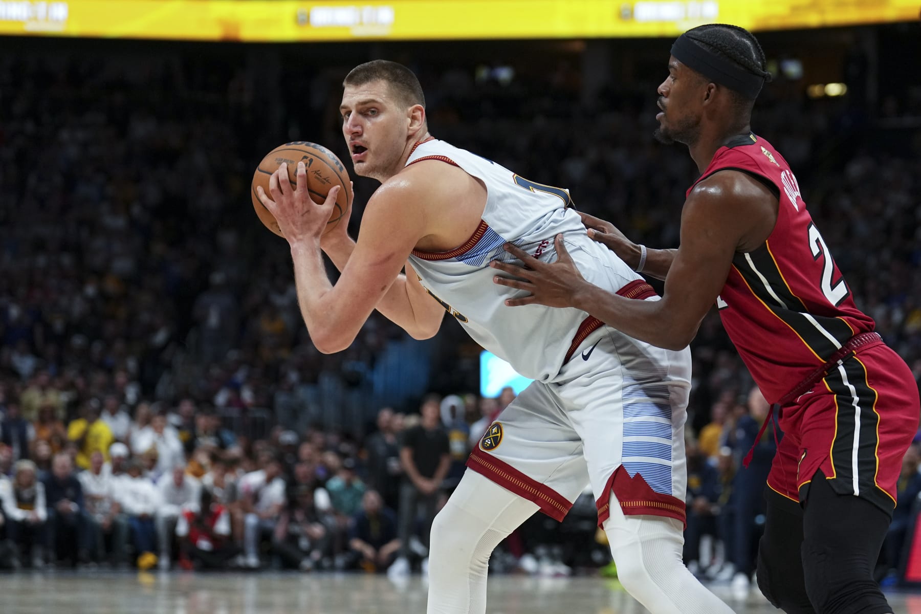 Denver Nuggets center Nikola Jokic, left, is defended by Miami Heat forward Jimmy Butler, right, during the second half of Game 5 of basketball's NBA Finals, Monday, June 12, 2023, in Denver. (AP Photo/Jack Dempsey)
