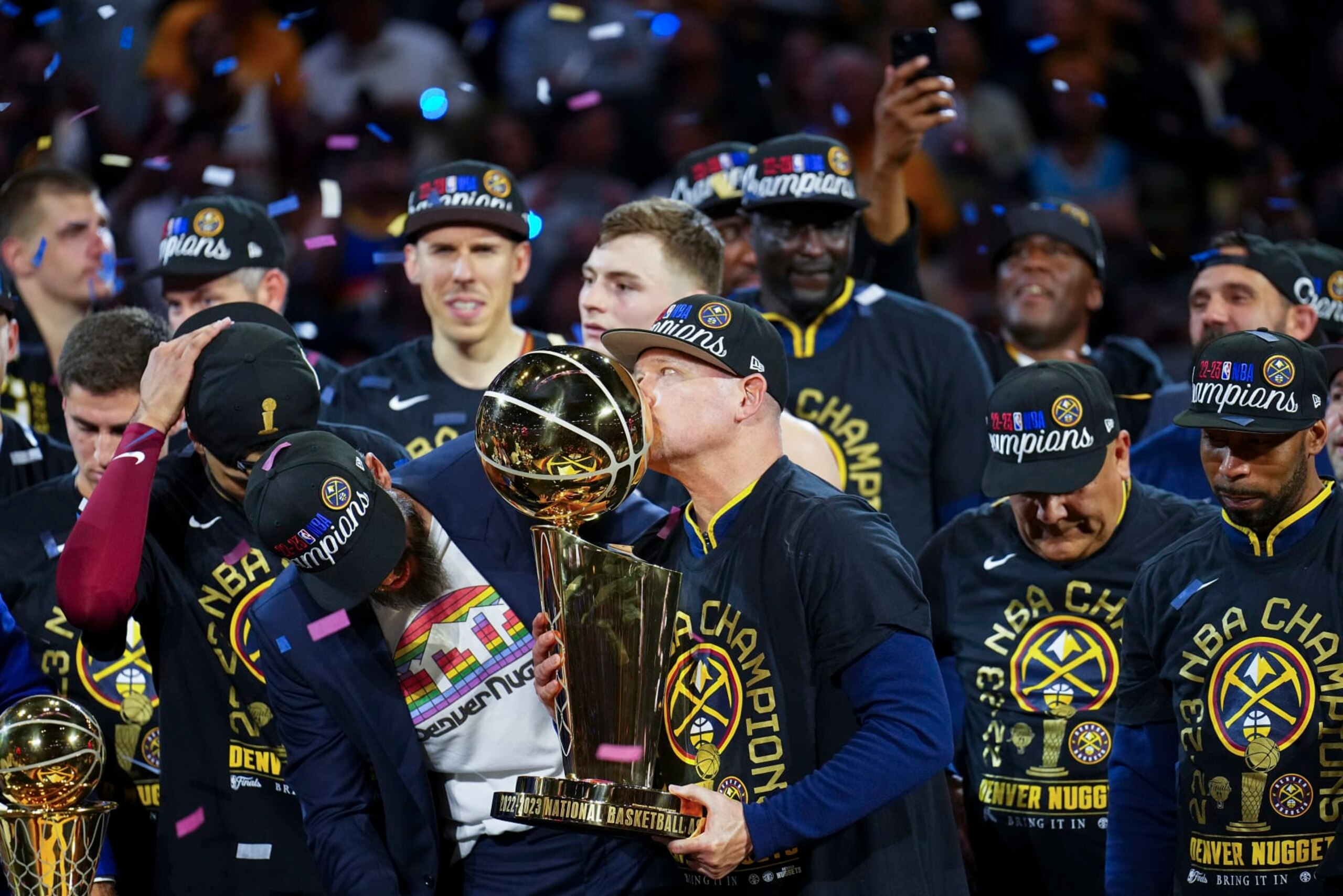 Denver Nuggets head coach Michael Malone, center, kisses the Larry O'Brien NBA Championship Trophy after the team's victory over the Miami Heat in Game 5 of basketball's NBA Finals, Monday, June 12, 2023, in Denver. (AP Photo/David Zalubowski)