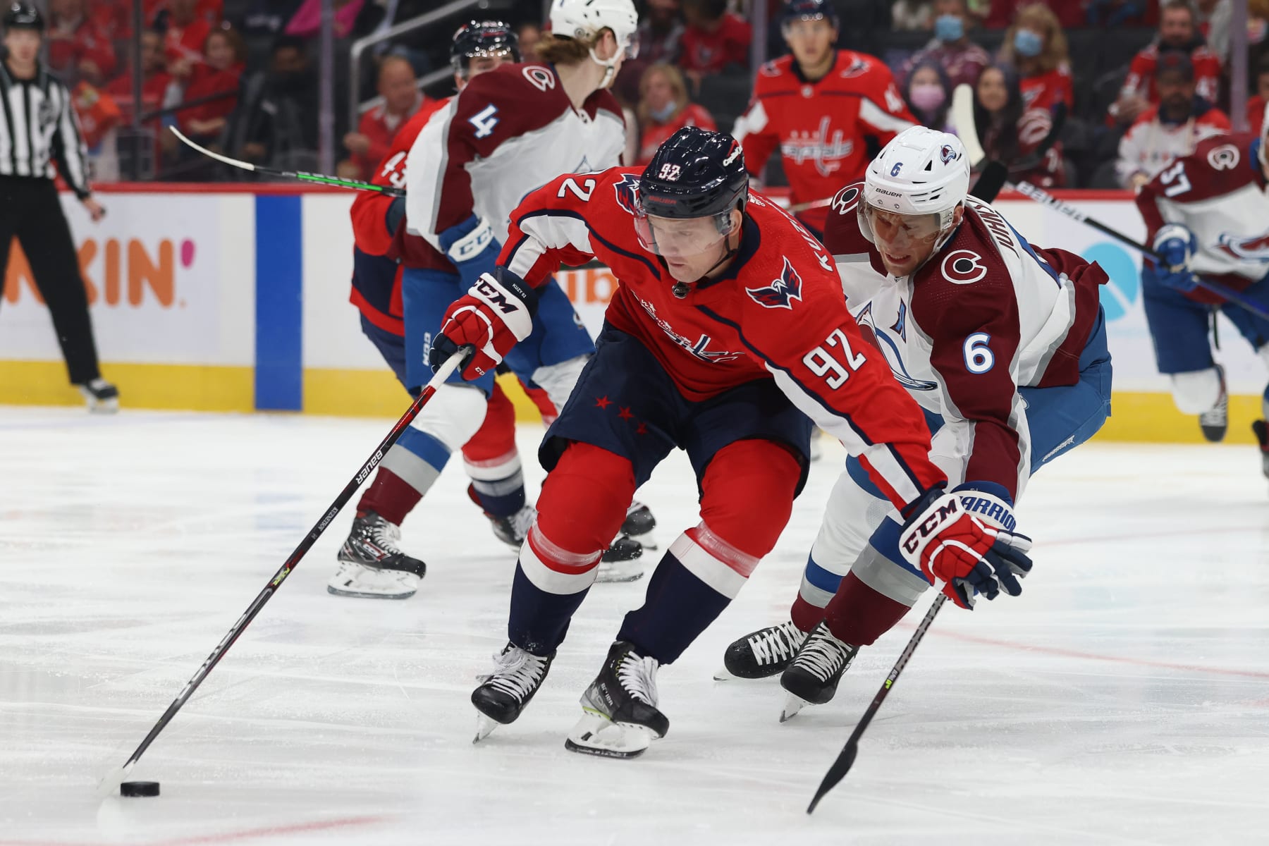 WASHINGTON, DC - OCTOBER 19: Evgeny Kuznetsov #92 of the Washington Capitals drives through Erik Johnson #6 of the Colorado Avalanche during a game at Capital One Arena on October 19, 2021 in Washington, D.C. (Photo by John McCreary/NHLI via Getty Images)