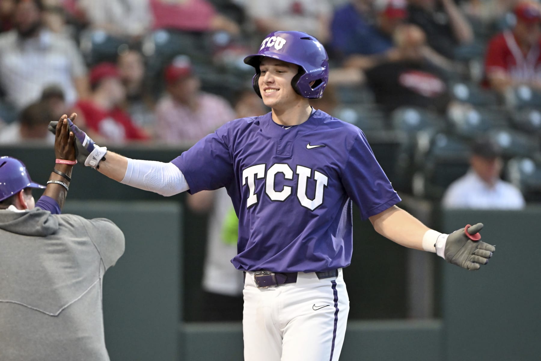 TCU batter Brayden Taylor is greeted by teammates after hitting home run against Arizona during an NCAA baseball game on Friday, June 2, 2023, in Fayetteville, Ark. (AP Photo/Michael Woods)