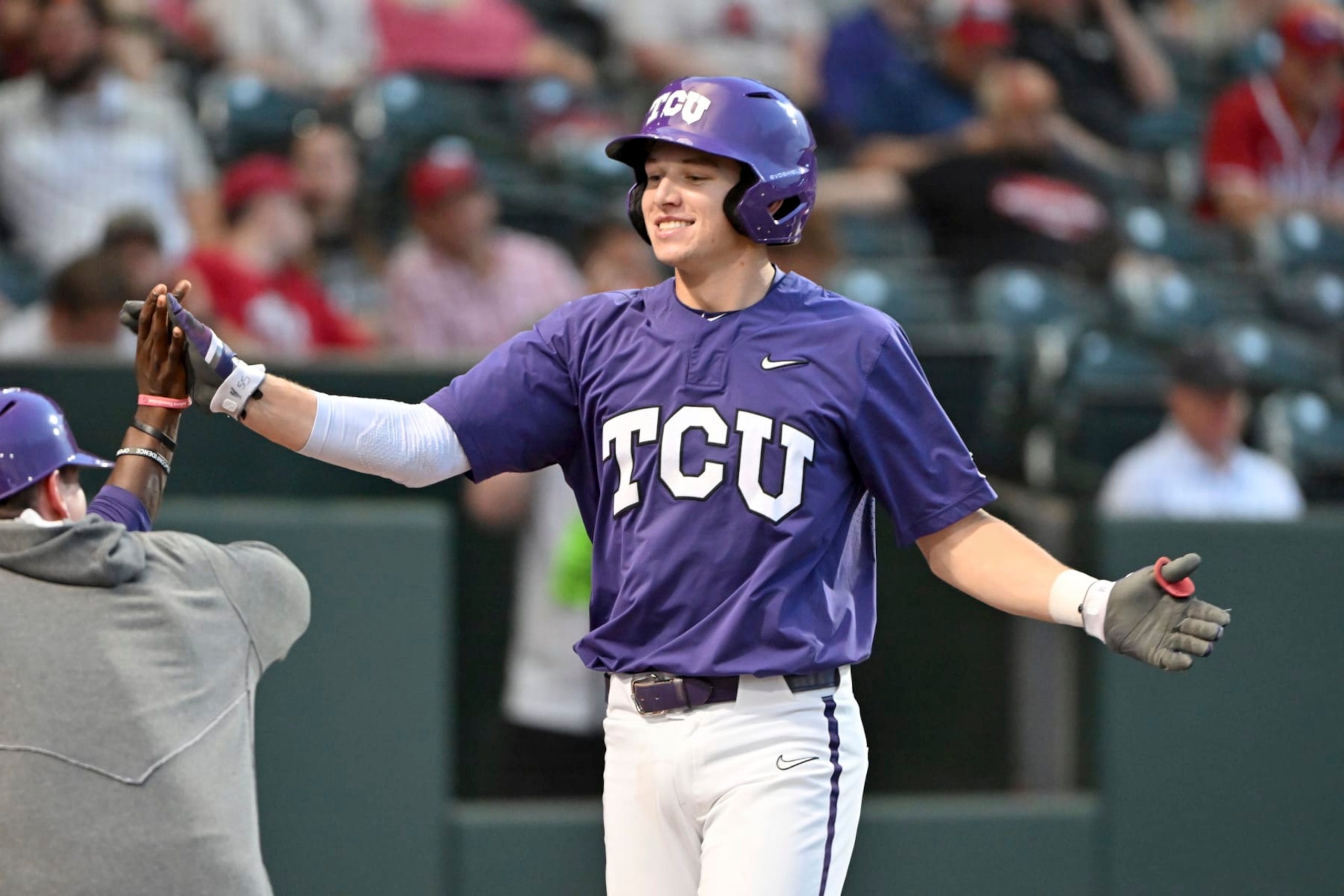 TCU batter Brayden Taylor is greeted by teammates after hitting home run against Arizona during an NCAA baseball game on Friday, June 2, 2023, in Fayetteville, Ark. (AP Photo/Michael Woods)