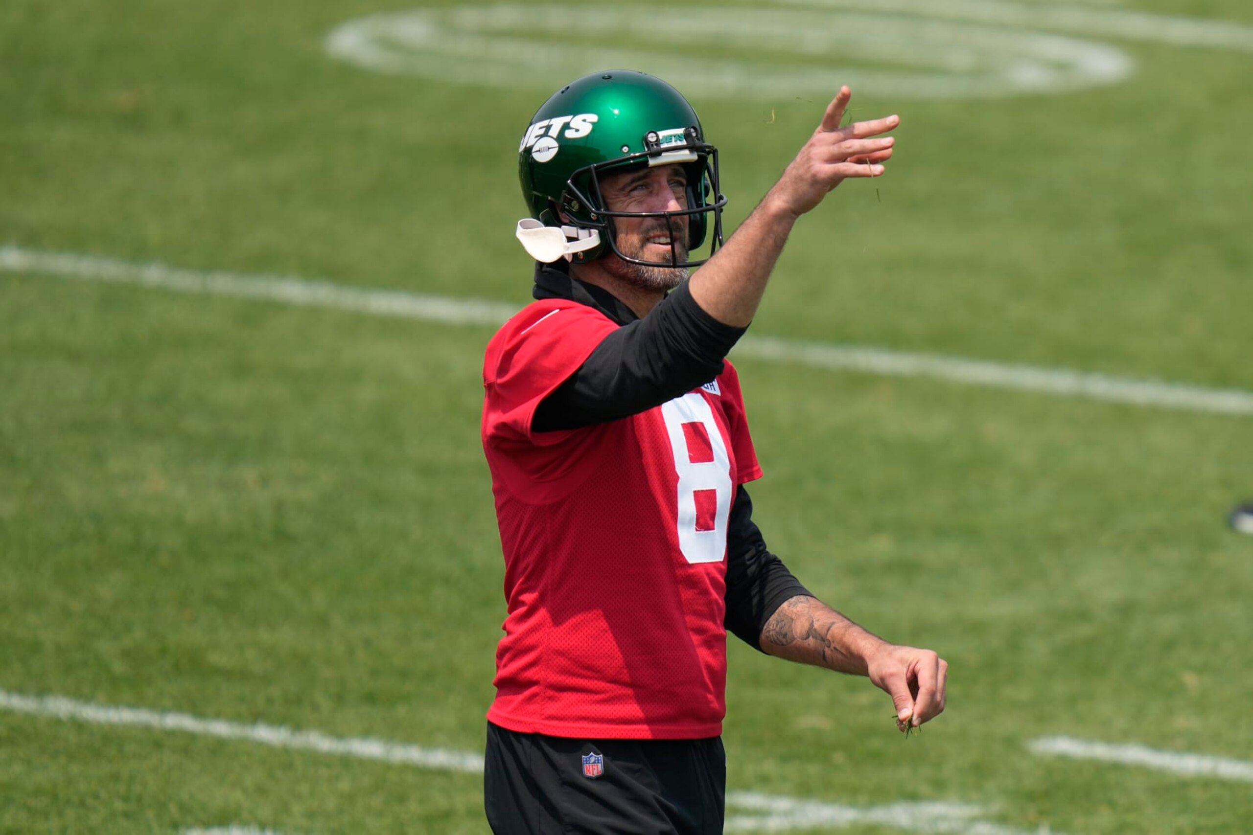 New York Jets quarterback Aaron Rodgers throws grass in the air at the NFL football team's training facility in Florham Park, N.J., Tuesday, June 6, 2023. (AP Photo/Seth Wenig) New York Jets quarterback Aaron Rodgers throws grass in the air at the NFL football team's training facility in Florham Park, N.J., Tuesday, June 6, 2023. (AP Photo/Seth Wenig)