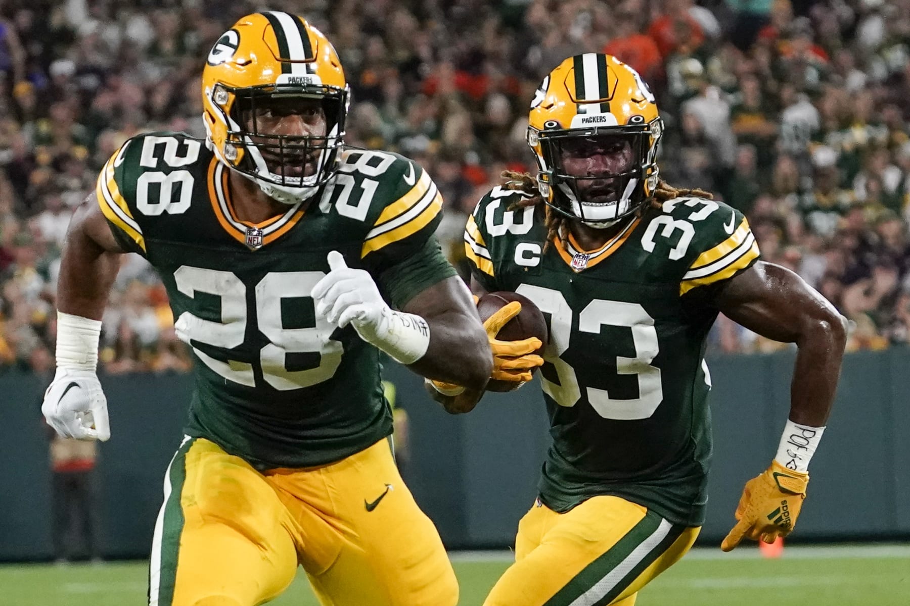 Green Bay Packers' AJ Dillon blo ks for Aaron Jones during the first half of an NFL football game against the Chicago Bears Sunday, Sept. 18, 2022, in Green Bay, Wis. (AP Photo/Morry Gash)