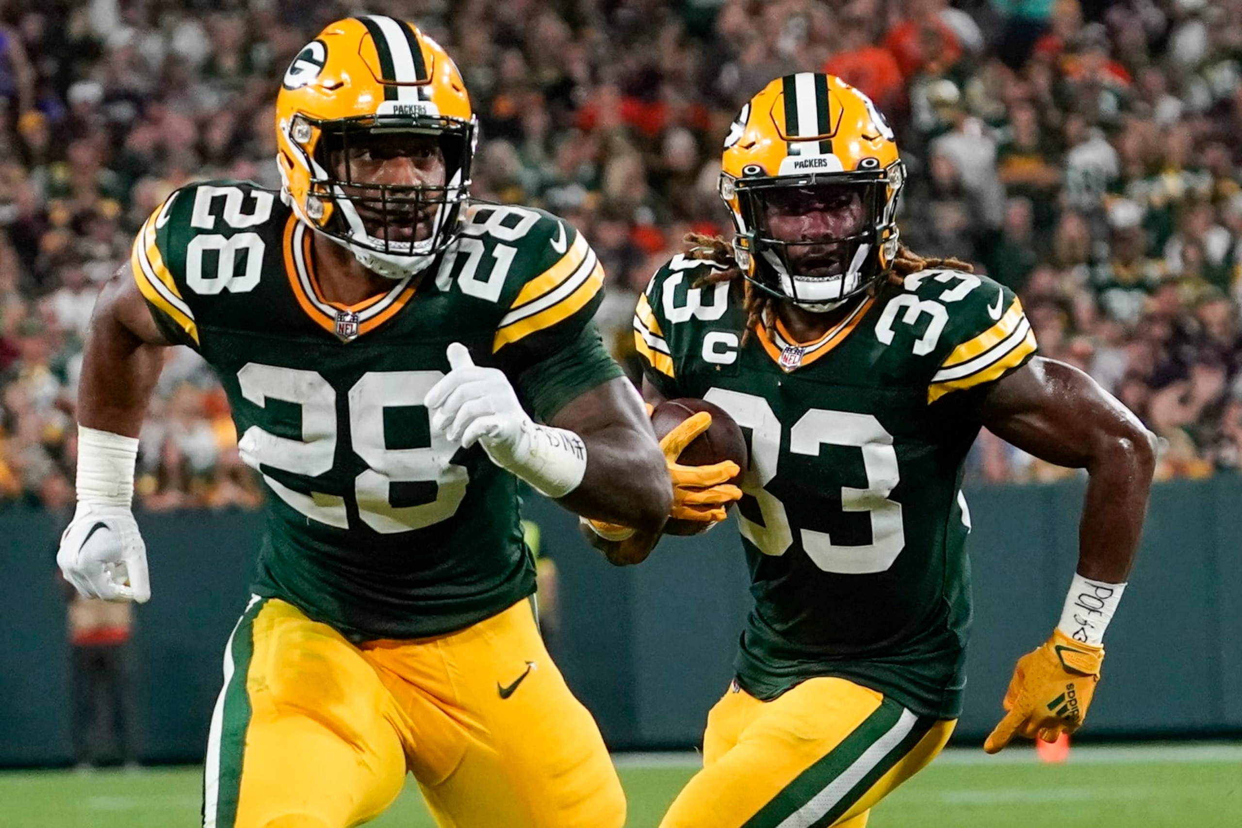 Green Bay Packers' AJ Dillon blo ks for Aaron Jones during the first half of an NFL football game against the Chicago Bears Sunday, Sept. 18, 2022, in Green Bay, Wis. (AP Photo/Morry Gash)