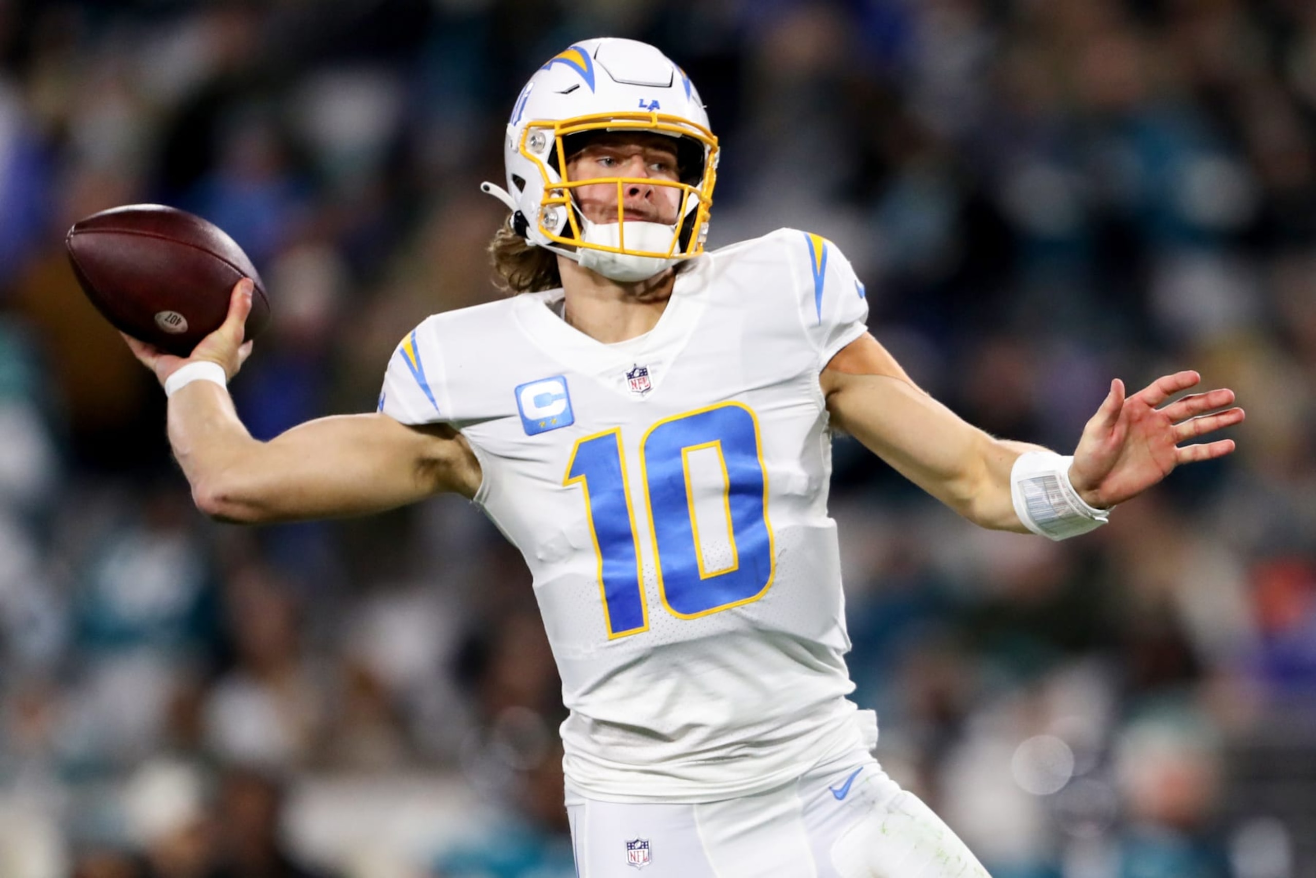 JACKSONVILLE, FLORIDA - JANUARY 14: Justin Herbert #10 of the Los Angeles Chargers throws a pass against the Jacksonville Jaguars during the first half of the game in the AFC Wild Card playoff game at TIAA Bank Field on January 14, 2023 in Jacksonville, Florida. (Photo by Courtney Culbreath/Getty Images)