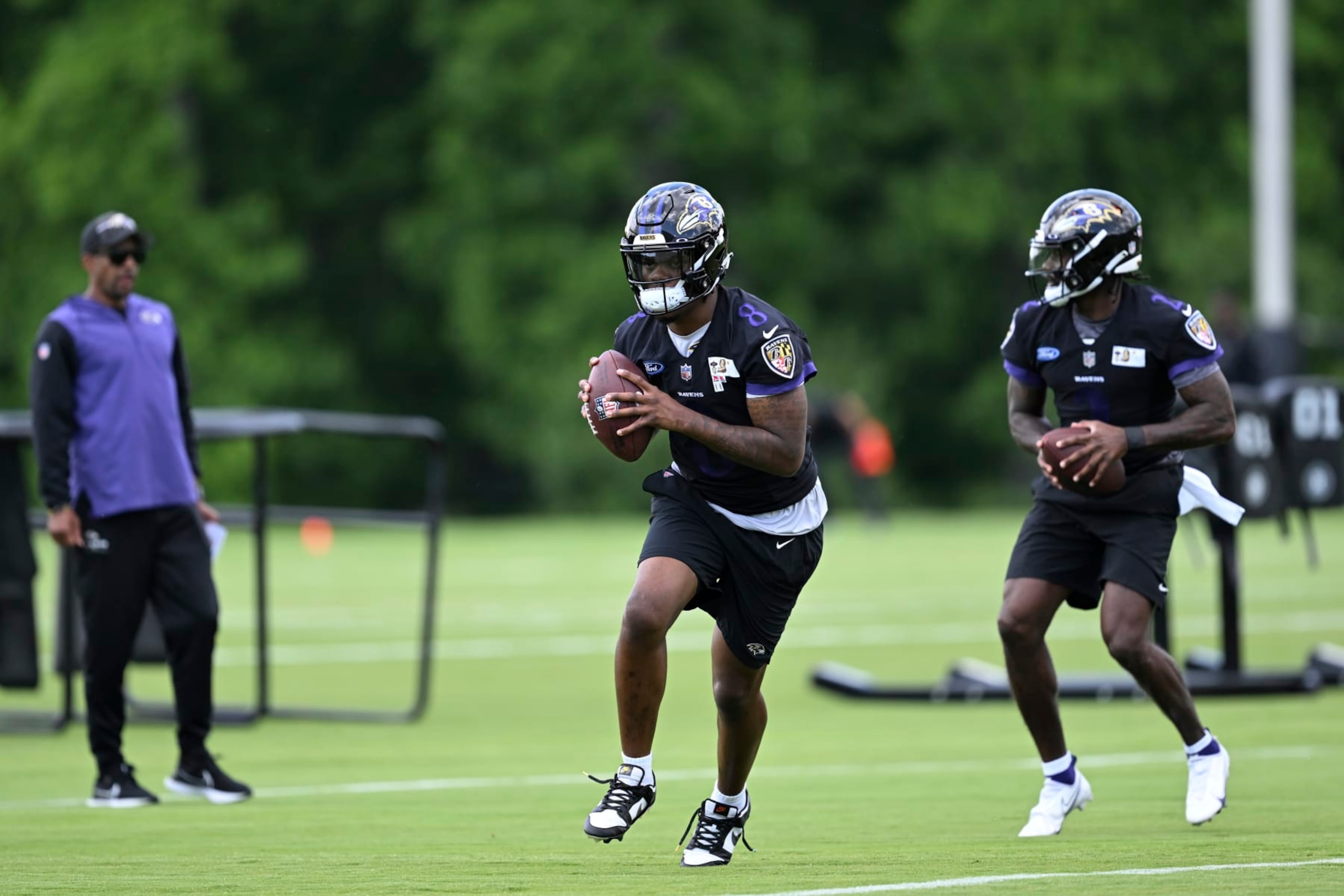Baltimore Ravens quarterback Lamar Jackson, left, and Tyler Huntley workout during NFL football practice Wednesday, June 14, 2023, in Owings Mills, Md. (AP Photo/Gail Burton)