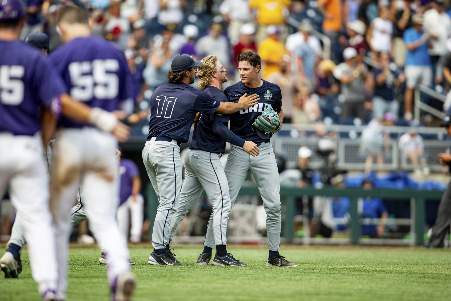Oral Roberts pitcher Cade Denton, right, is congratulated by Harley Gollert (11) and Drew Stahl, second from right, after their victory over TCU in a baseball game at the NCAA College World Series in Omaha, Neb., Friday, June 16, 2023. (AP Photo/John Peterson)