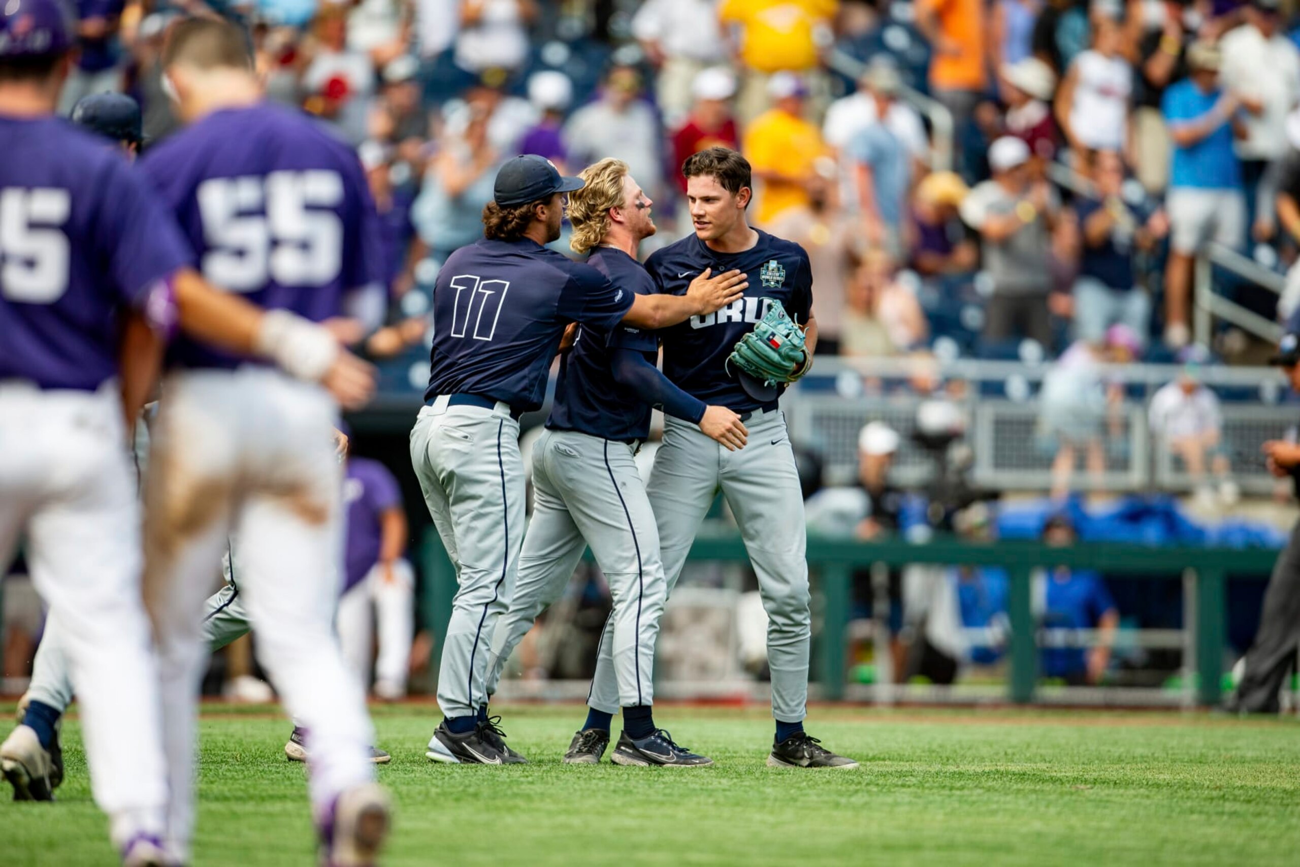 Oral Roberts pitcher Cade Denton, right, is congratulated by Harley Gollert (11) and Drew Stahl, second from right, after their victory over TCU in a baseball game at the NCAA College World Series in Omaha, Neb., Friday, June 16, 2023. (AP Photo/John Peterson) Oral Roberts pitcher Cade Denton, right, is congratulated by Harley Gollert (11) and Drew Stahl, second from right, after their victory over TCU in a baseball game at the NCAA College World Series in Omaha, Neb., Friday, June 16, 2023. (AP Photo/John Peterson)