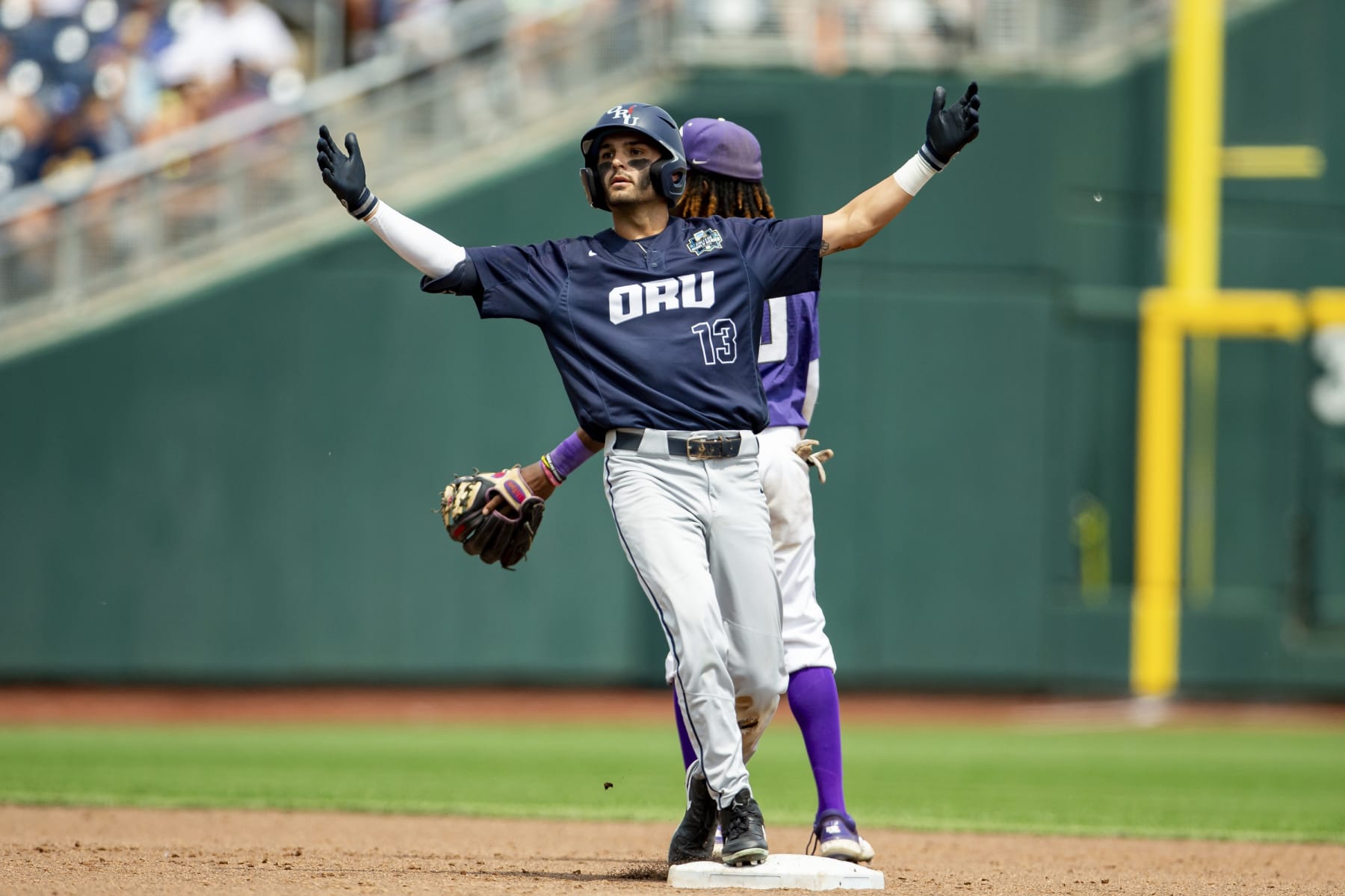 Oral Roberts' Justin Quinn (13) celebrates after a double against TCU in the sixth inning of a baseball game at the NCAA College World Series in Omaha, Neb., Friday, June 16, 2023. (AP Photo/John Peterson)