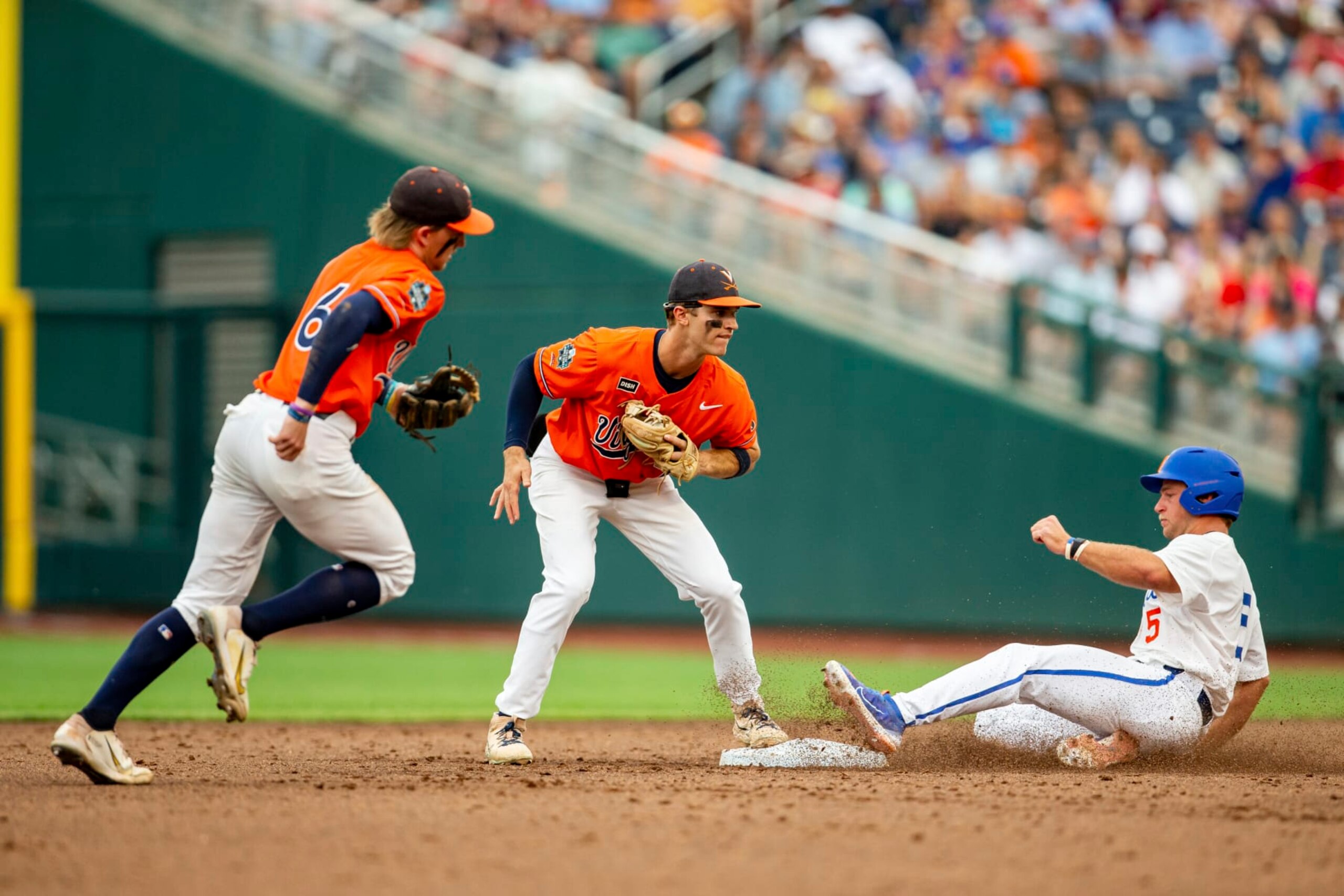 Virginia second baseman Henry Godbout, center, forces out Florida's Colby Halter, right, in the second inning of a baseball game at the NCAA College World Series in Omaha, Neb., Friday, June 16, 2023. (AP Photo/John Peterson) Virginia second baseman Henry Godbout, center, forces out Florida's Colby Halter, right, in the second inning of a baseball game at the NCAA College World Series in Omaha, Neb., Friday, June 16, 2023. (AP Photo/John Peterson)