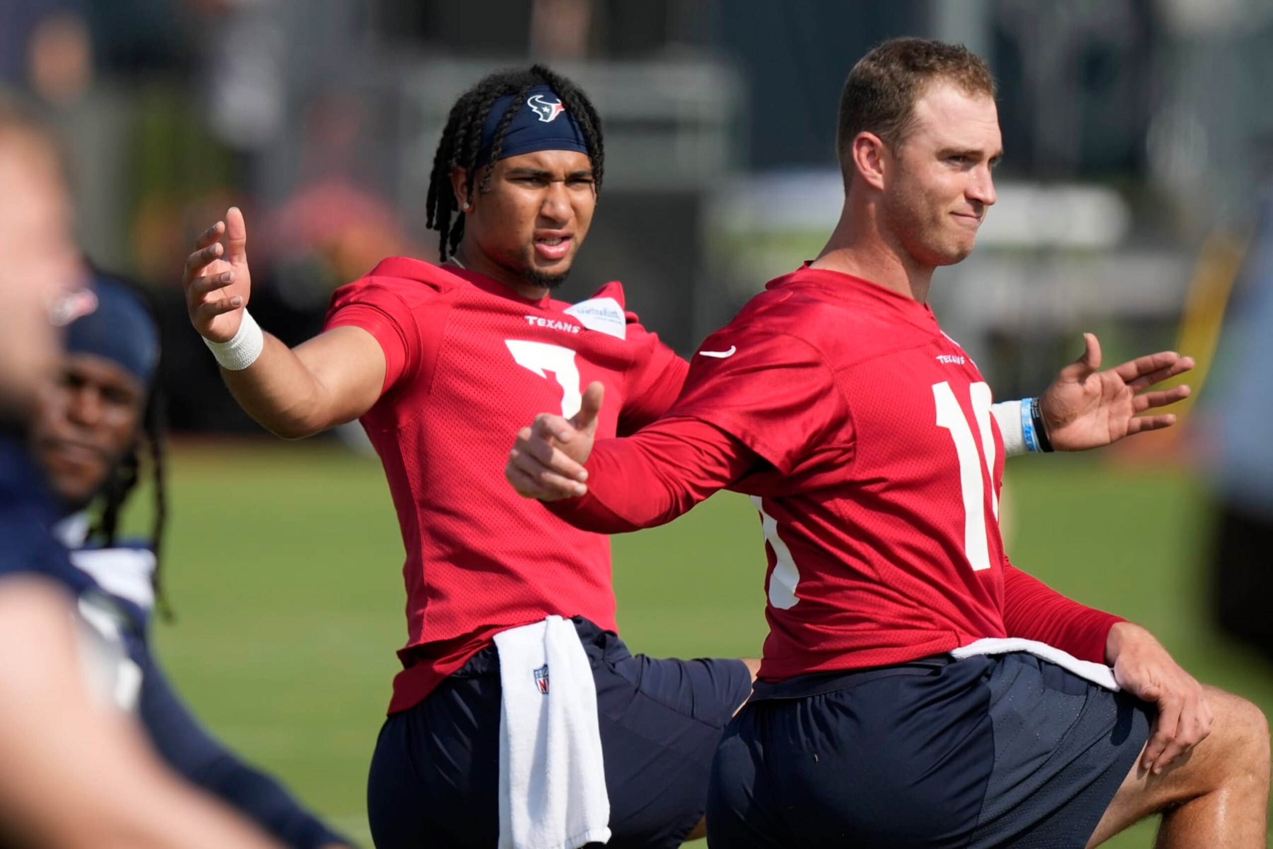 Houston Texans quarterbacks C.J. Stroud (7) and Davis Mills(10) stretch during an organized team activity at the football team's training facility Tuesday, May 23, 2023, in Houston. (AP Photo/David J. Phillip)