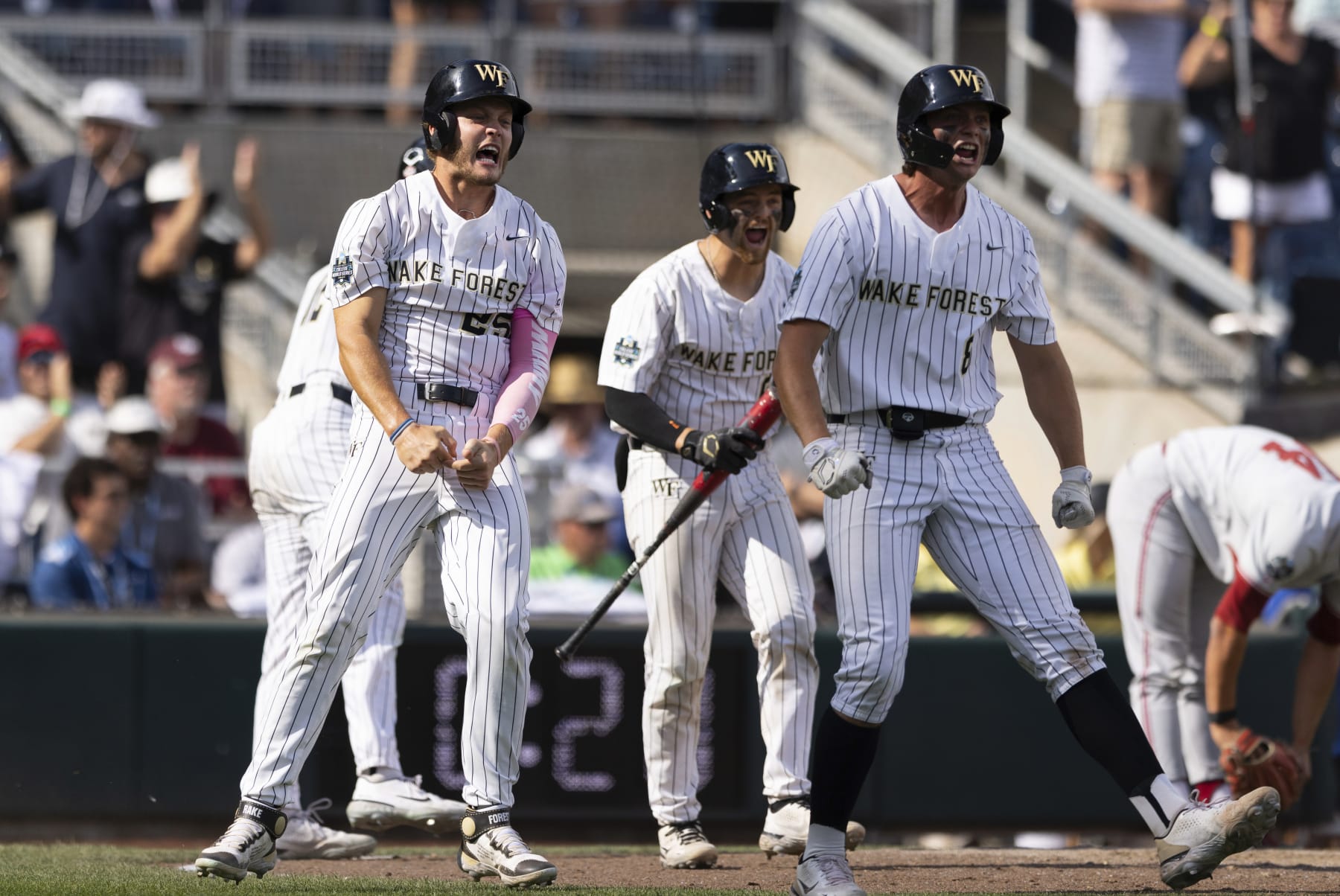 Wake Forest's Brock Wilken, left, and Nick Kurtz, right, celebrate after scoring on a single by Danny Corona against Stanford during the eighth inning of a baseball game at the NCAA College World Series in Omaha, Neb., Saturday, June 17, 2023. (AP Photo/Rebecca S. Gratz)