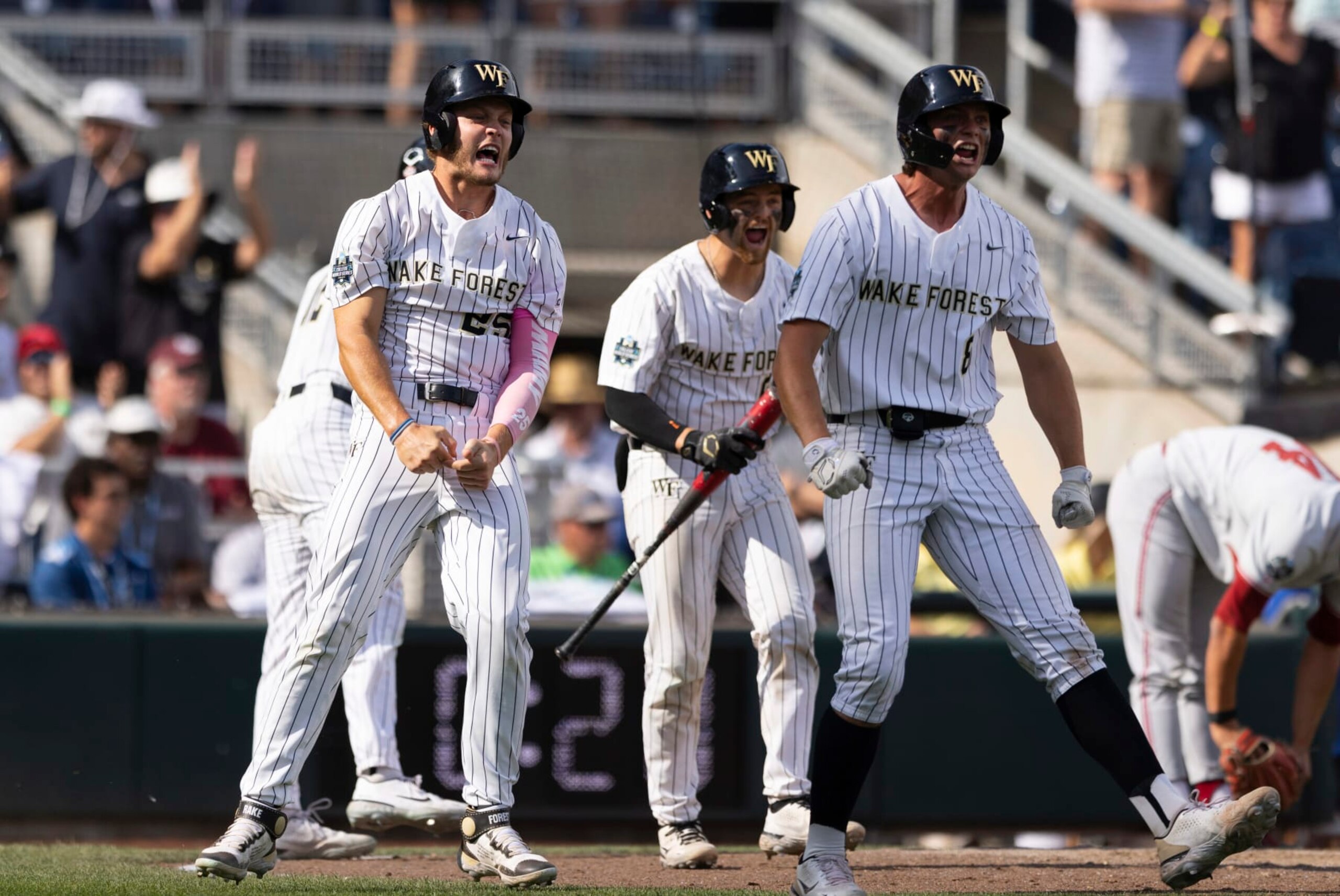 Wake Forest's Brock Wilken, left, and Nick Kurtz, right, celebrate after scoring on a single by Danny Corona against Stanford during the eighth inning of a baseball game at the NCAA College World Series in Omaha, Neb., Saturday, June 17, 2023. (AP Photo/Rebecca S. Gratz)