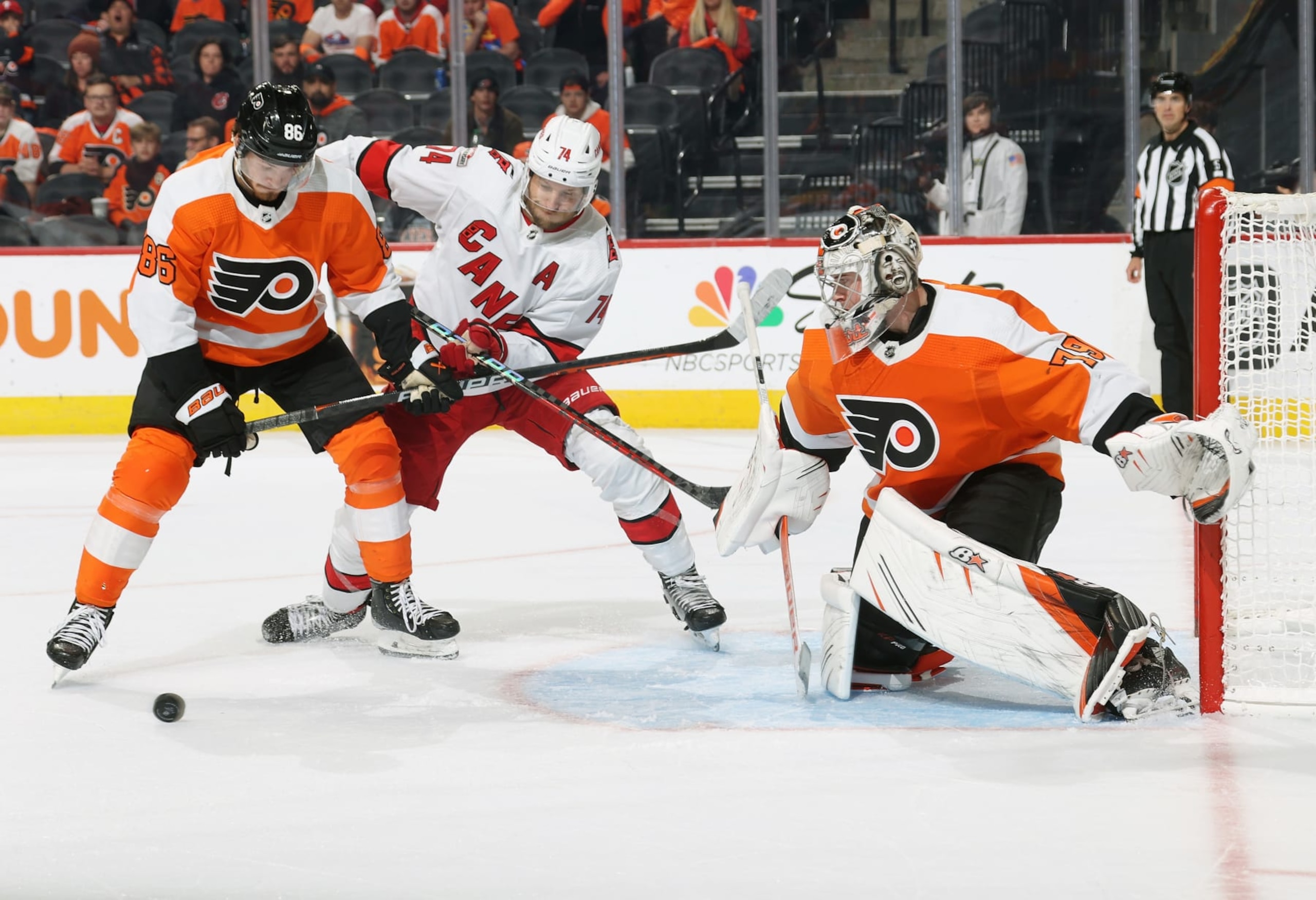PHILADELPHIA, PENNSYLVANIA - OCTOBER 29: Carter Hart #79 of the Philadelphia Flyers protects his net as Joel Farabee #86 battles for control of the loose puck with Jaccob Slavin #74 of the Carolina Hurricanes at the Wells Fargo Center on October 29, 2022 in Philadelphia, Pennsylvania. The Hurricanes went on to defeat the Flyers 4-3 in overtime. (Photo by Len Redkoles/NHLI via Getty Images)