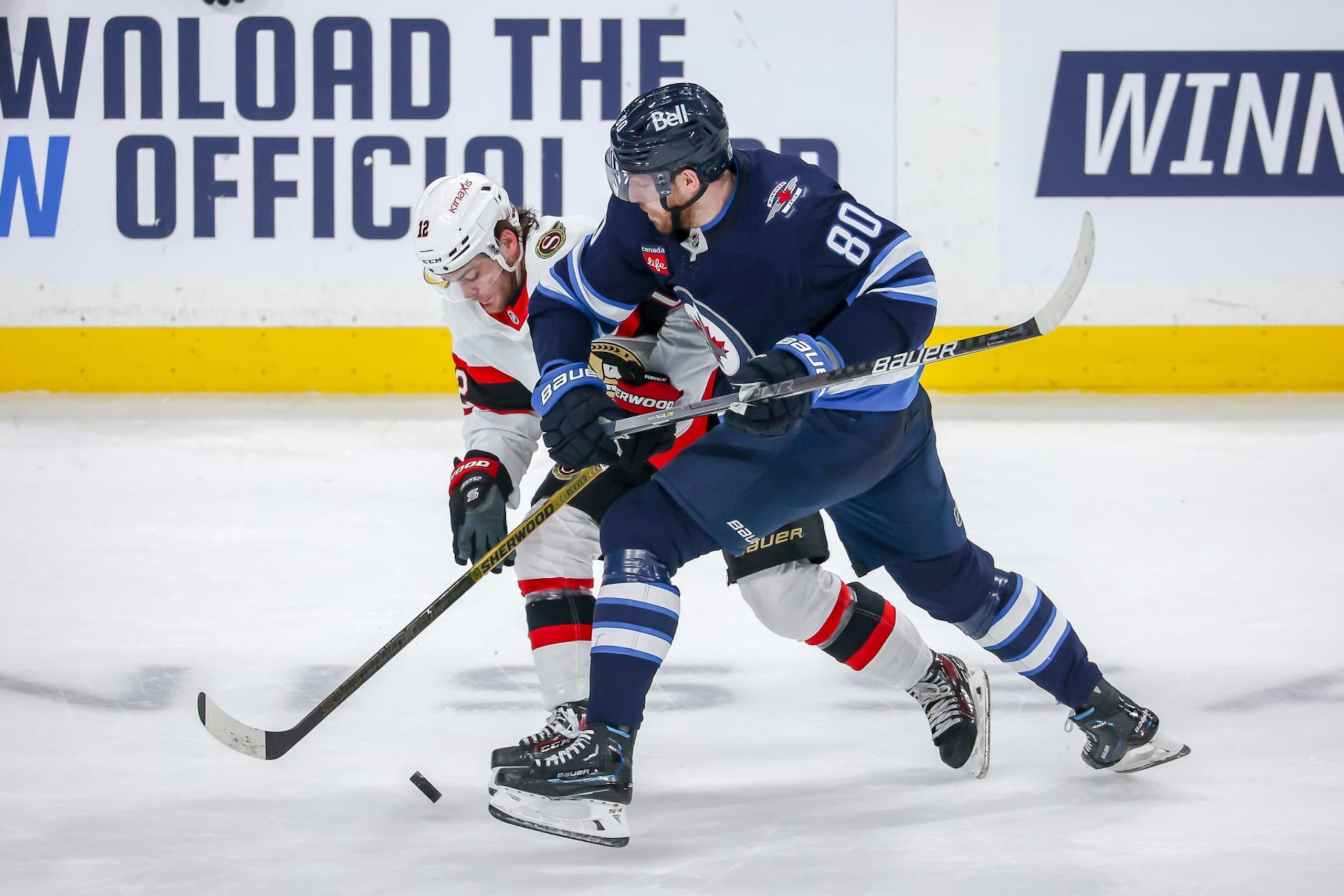 Winnipeg Jets center Pierre-Luc Dubois (right) battles Ottawa Senators winger Alex DeBrincat.