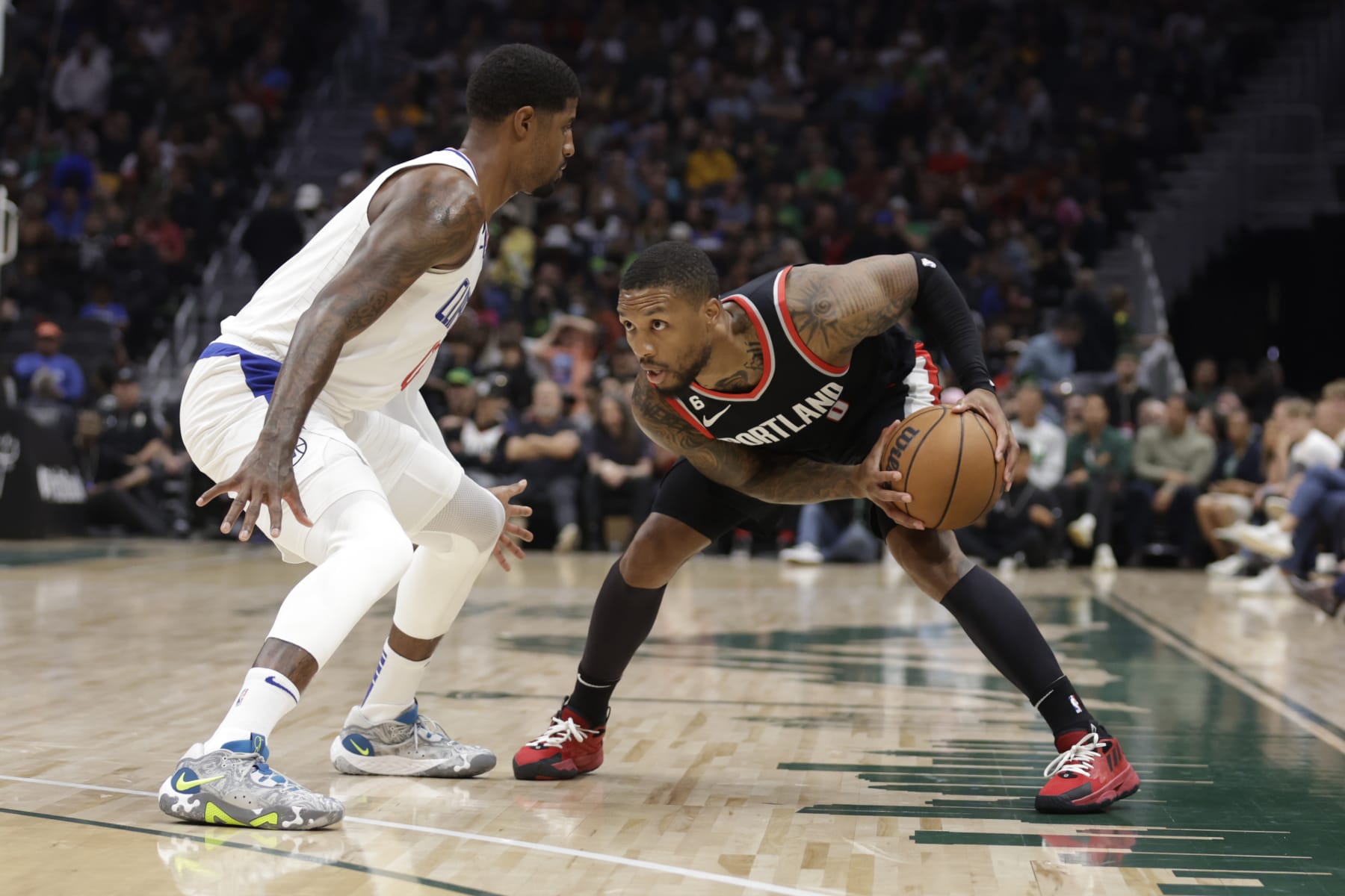 Portland Trailblazers' Damian Lillard works to keep the ball from Los Angeles Clippers' Paul George during the first half of a preseason NBA basketball game, Monday, Oct. 3, 2022, in Seattle. (AP Photo/ John Froschauer)